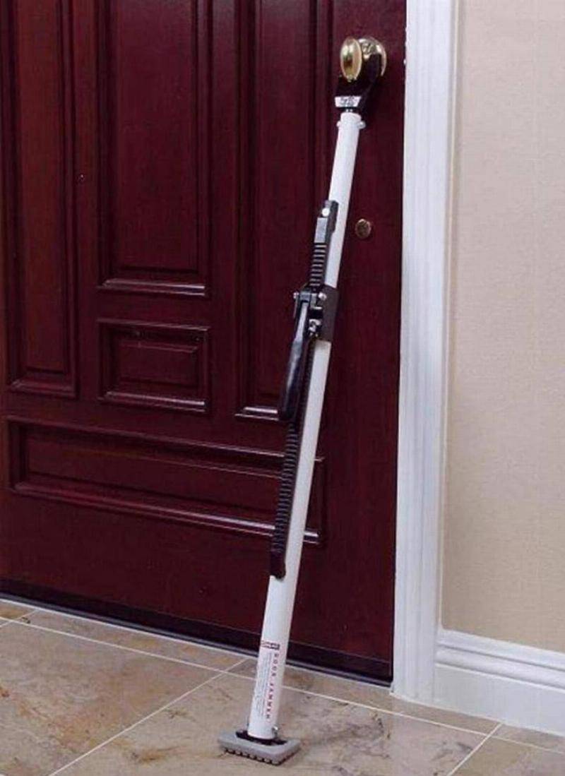 A door security bar is propped between the door knob and floor.