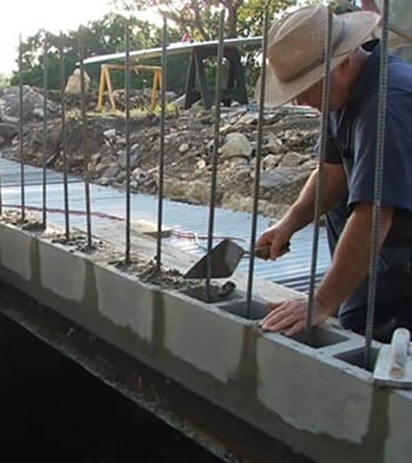 Man building concrete blocks for bunker.