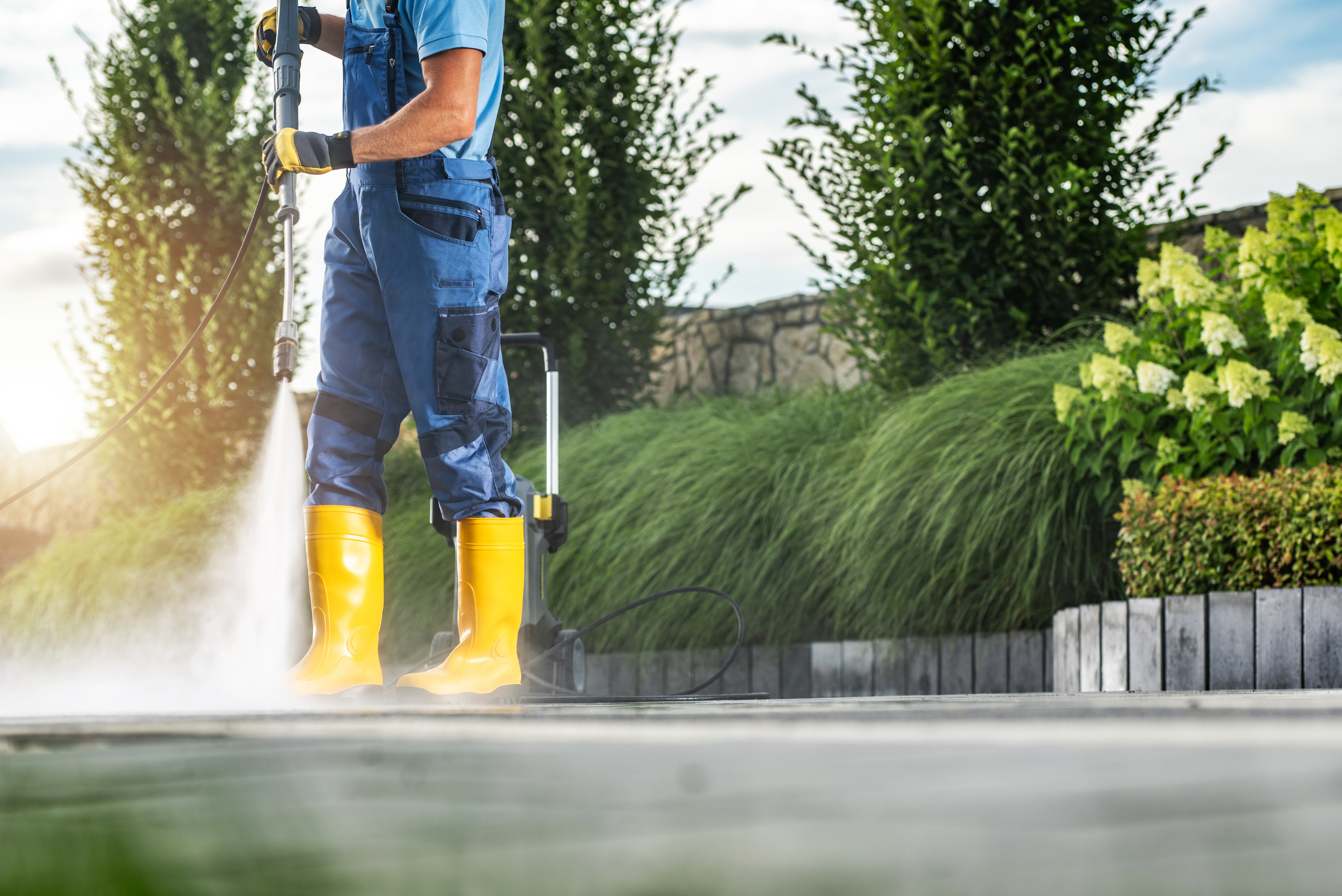 Pressure washing concrete driveway.