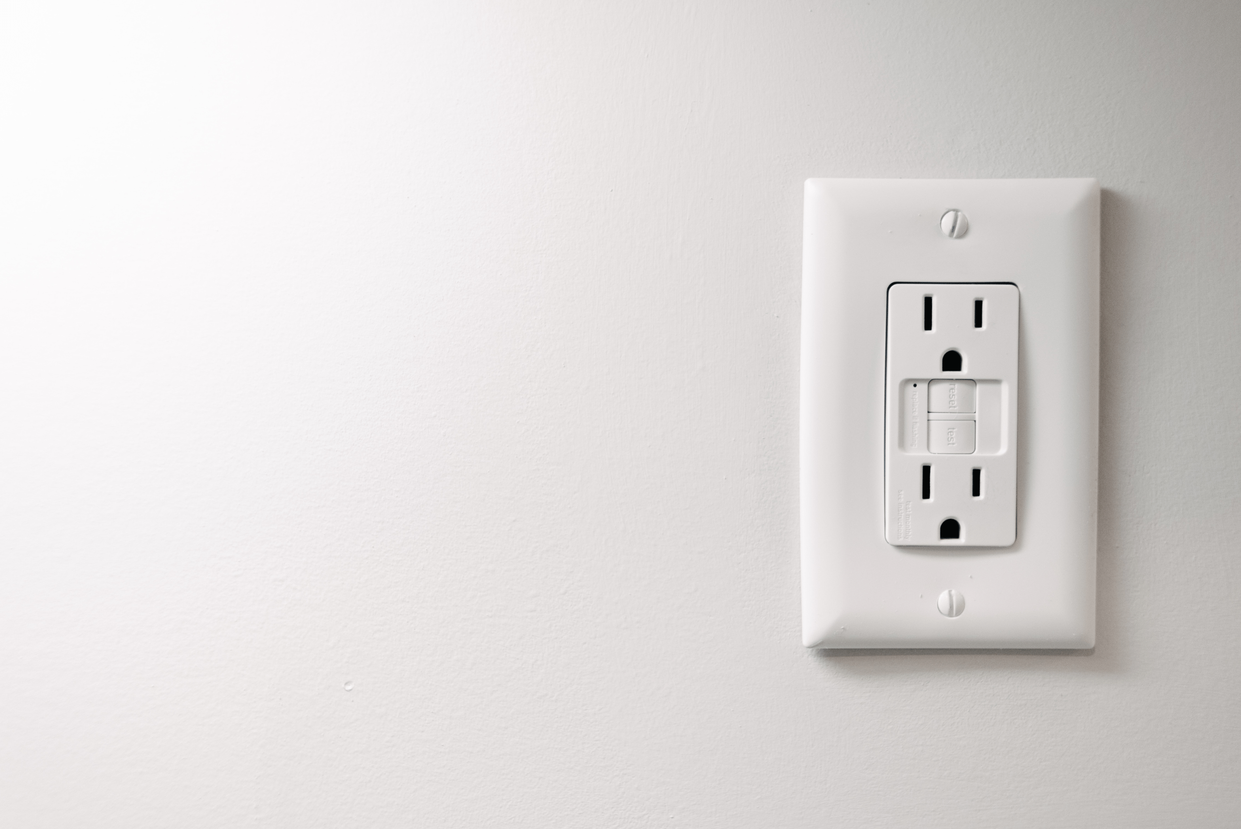 White GFCI outlet and wall.