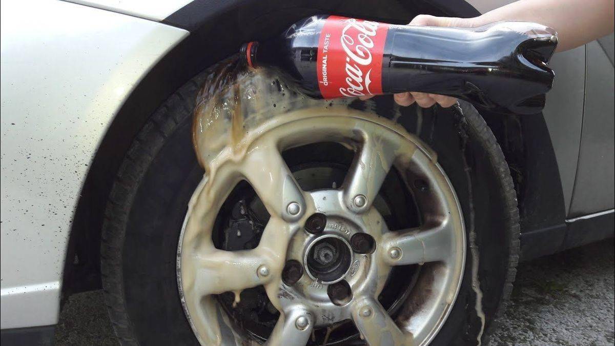 Pouring Coca Cola on a car's wheels.