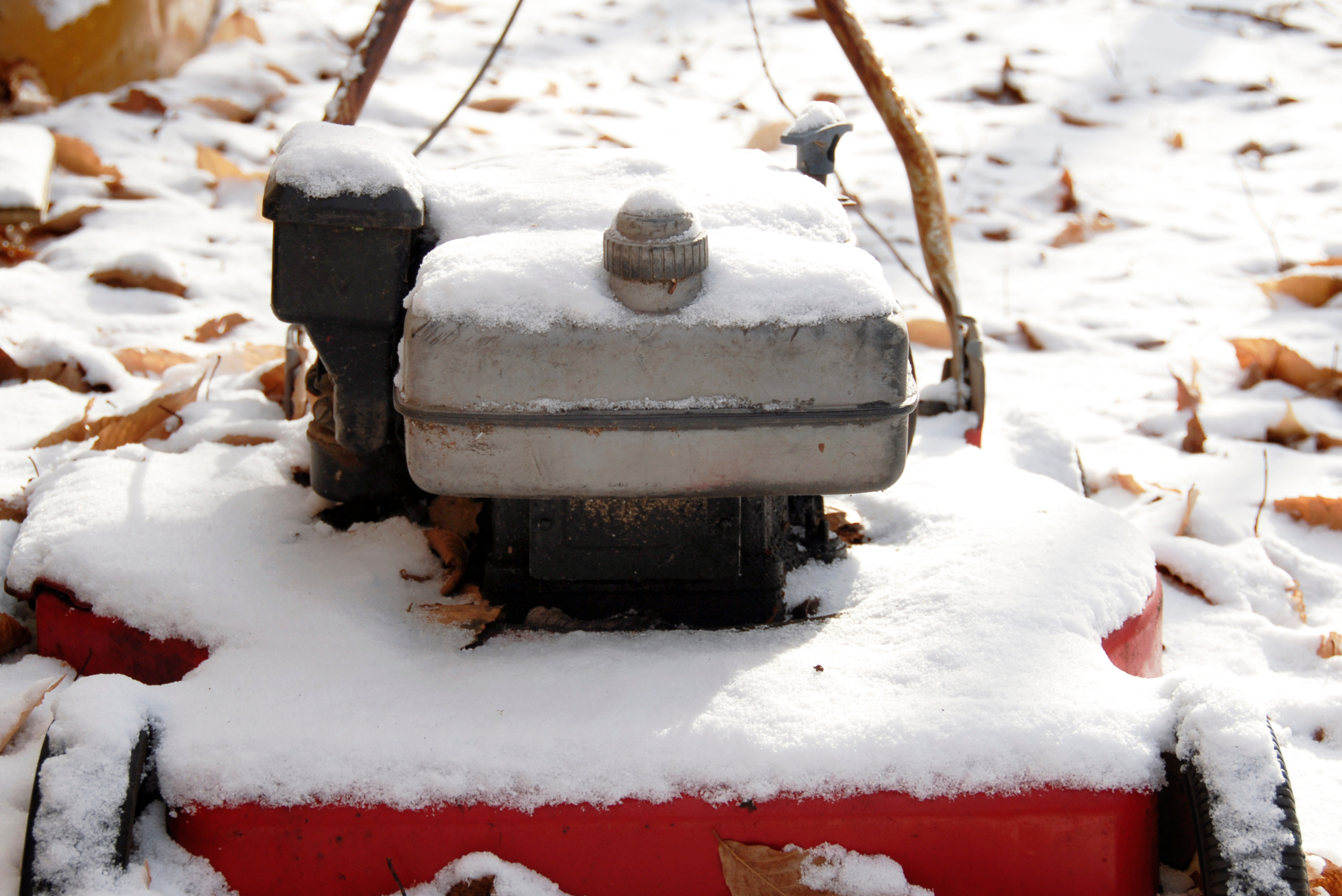 Lawn mower covered in snow.