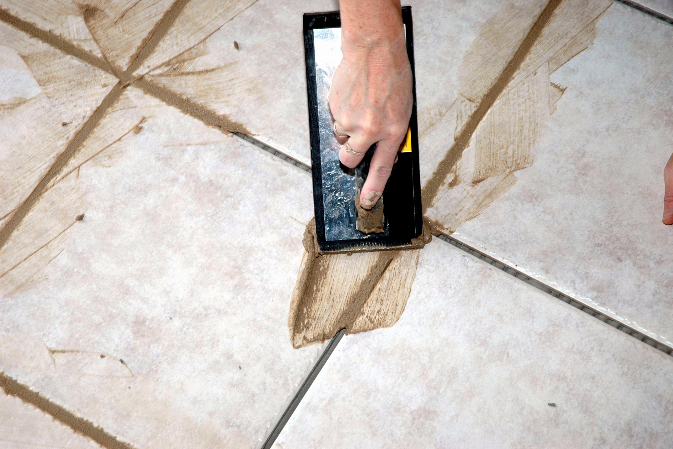 Spreading new grout bathroom tile.