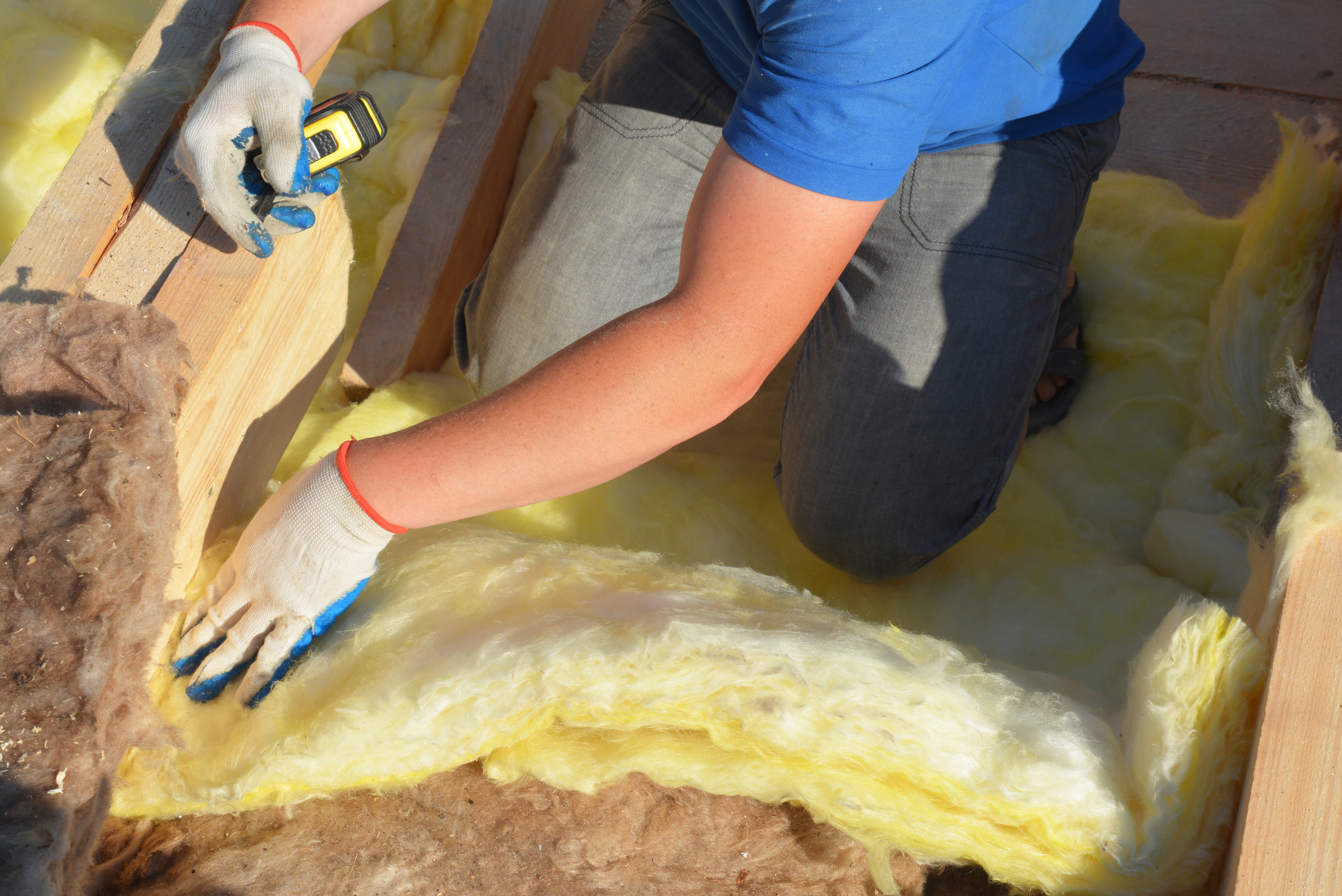 Worker grabbing insulation to install it.