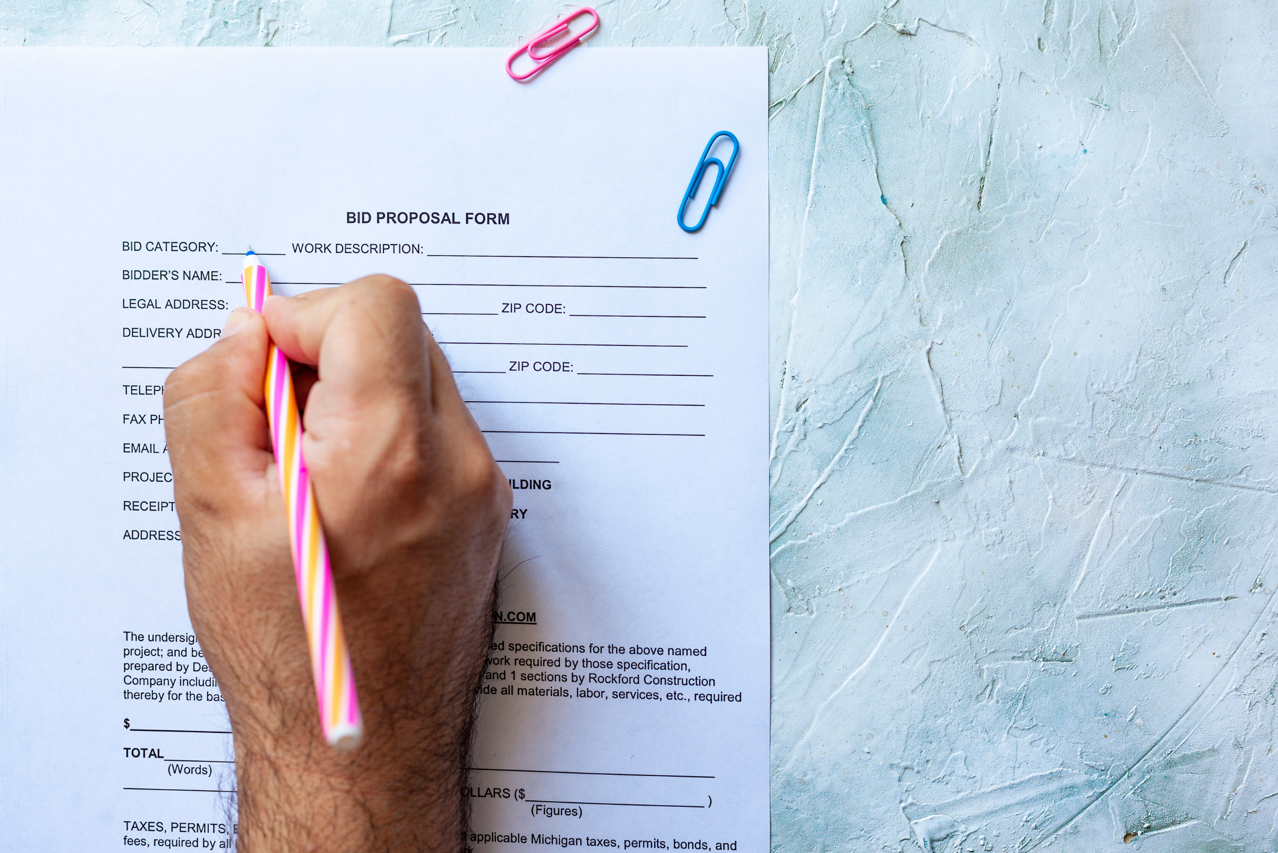 Closeup of someone's hand signing paperwork.