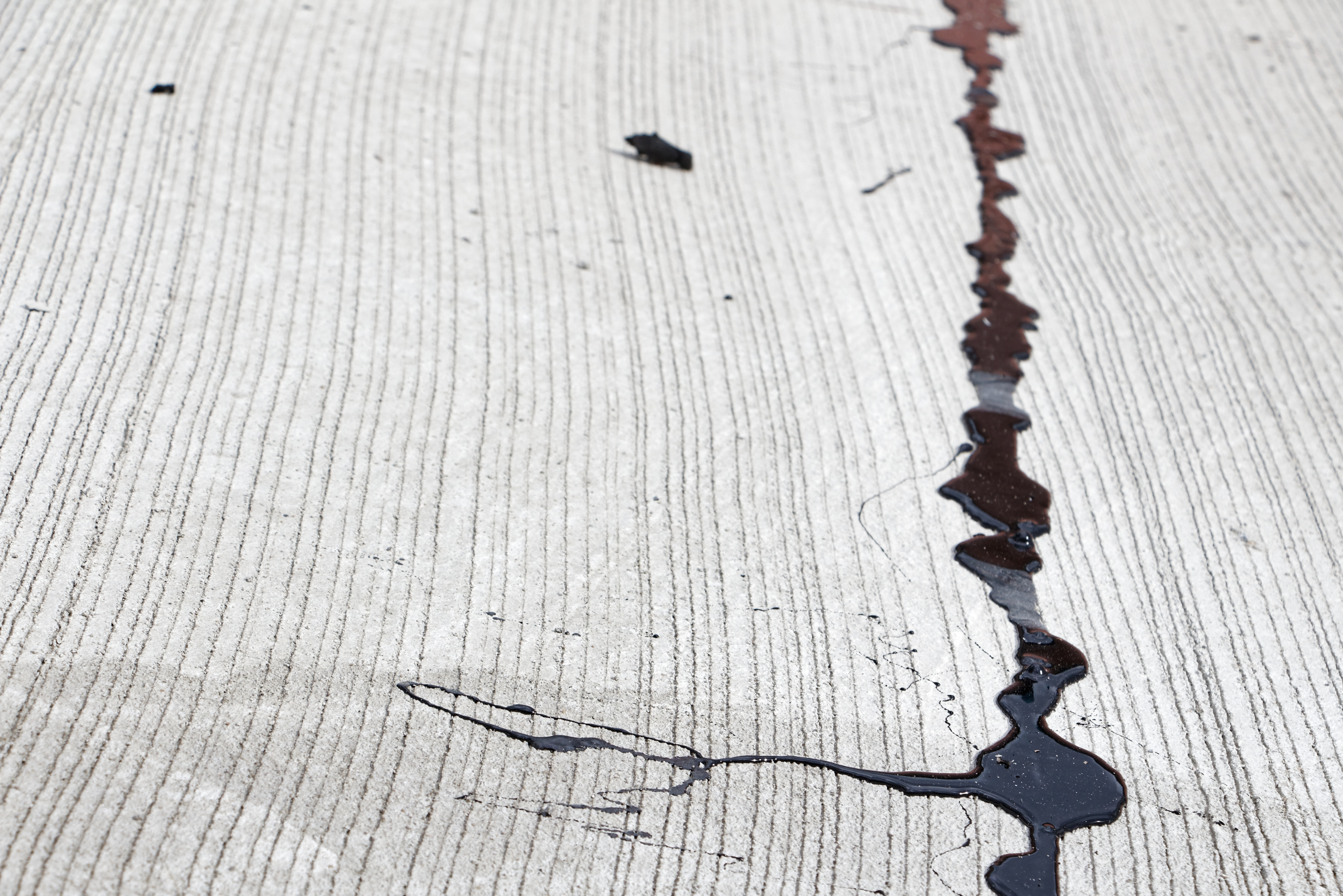 Sealed crack in a concrete driveway.