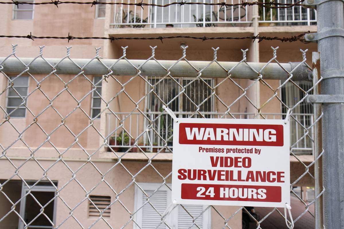 A warning sign on a fence says the home has security.