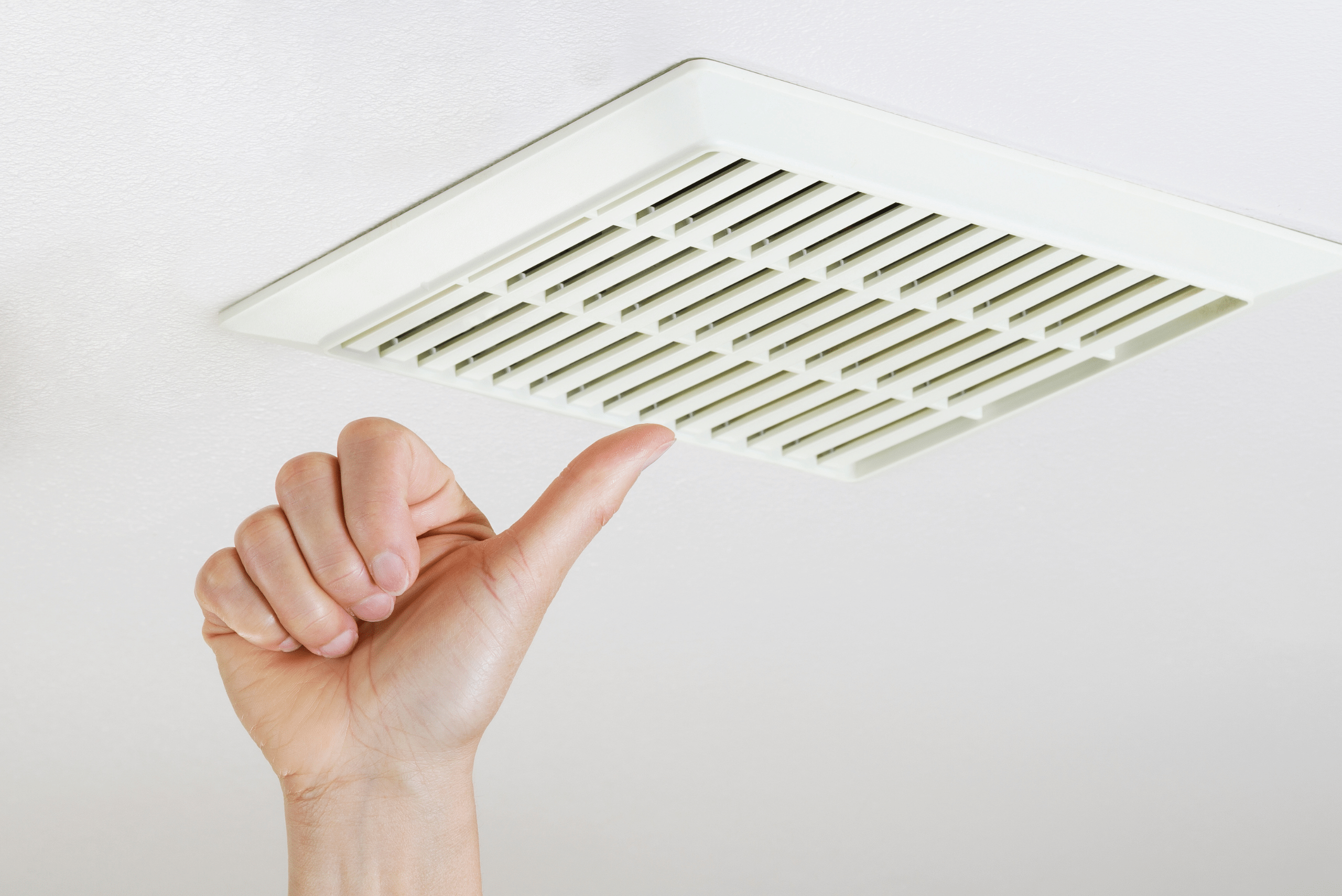 Clean bathroom vent and hand making a thumbs up gesture.