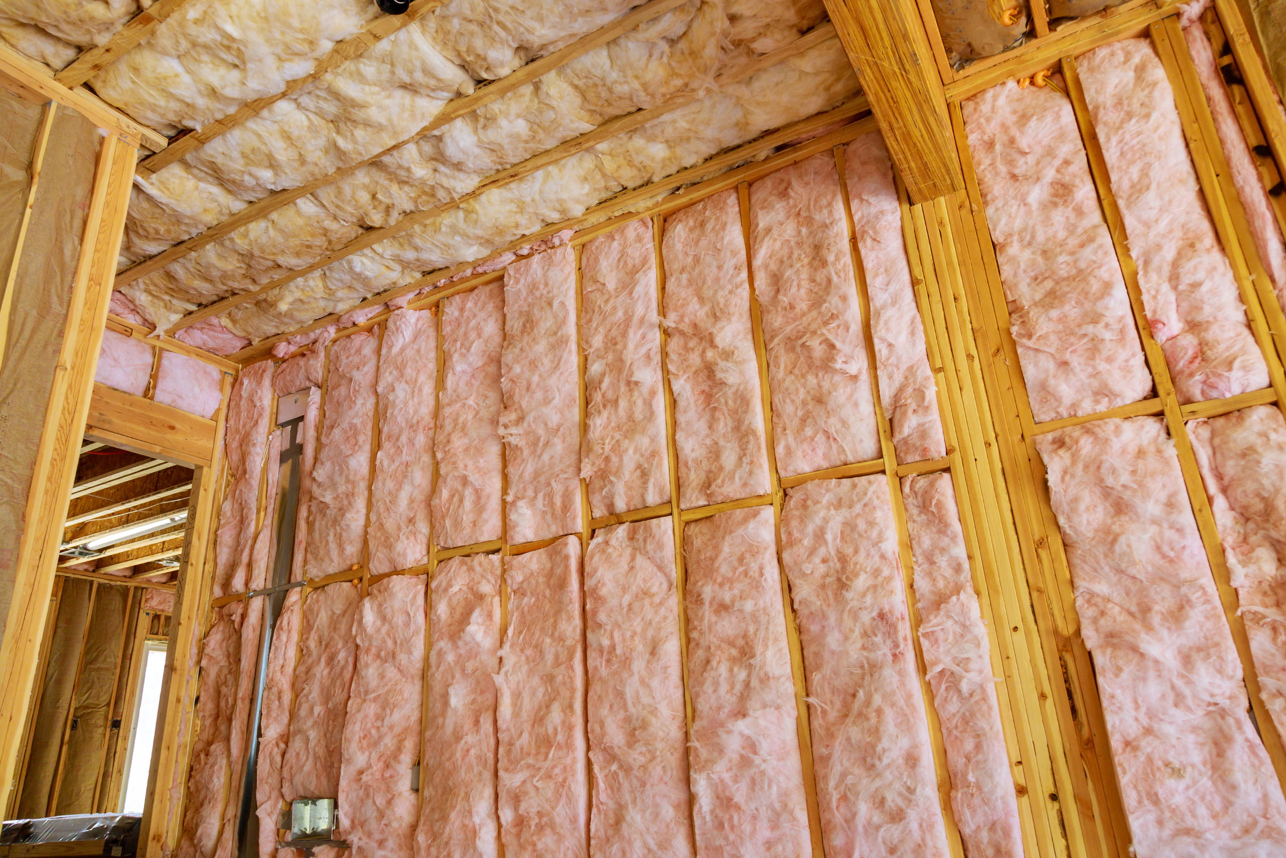 Installed insulation on the wooden frame of a room.