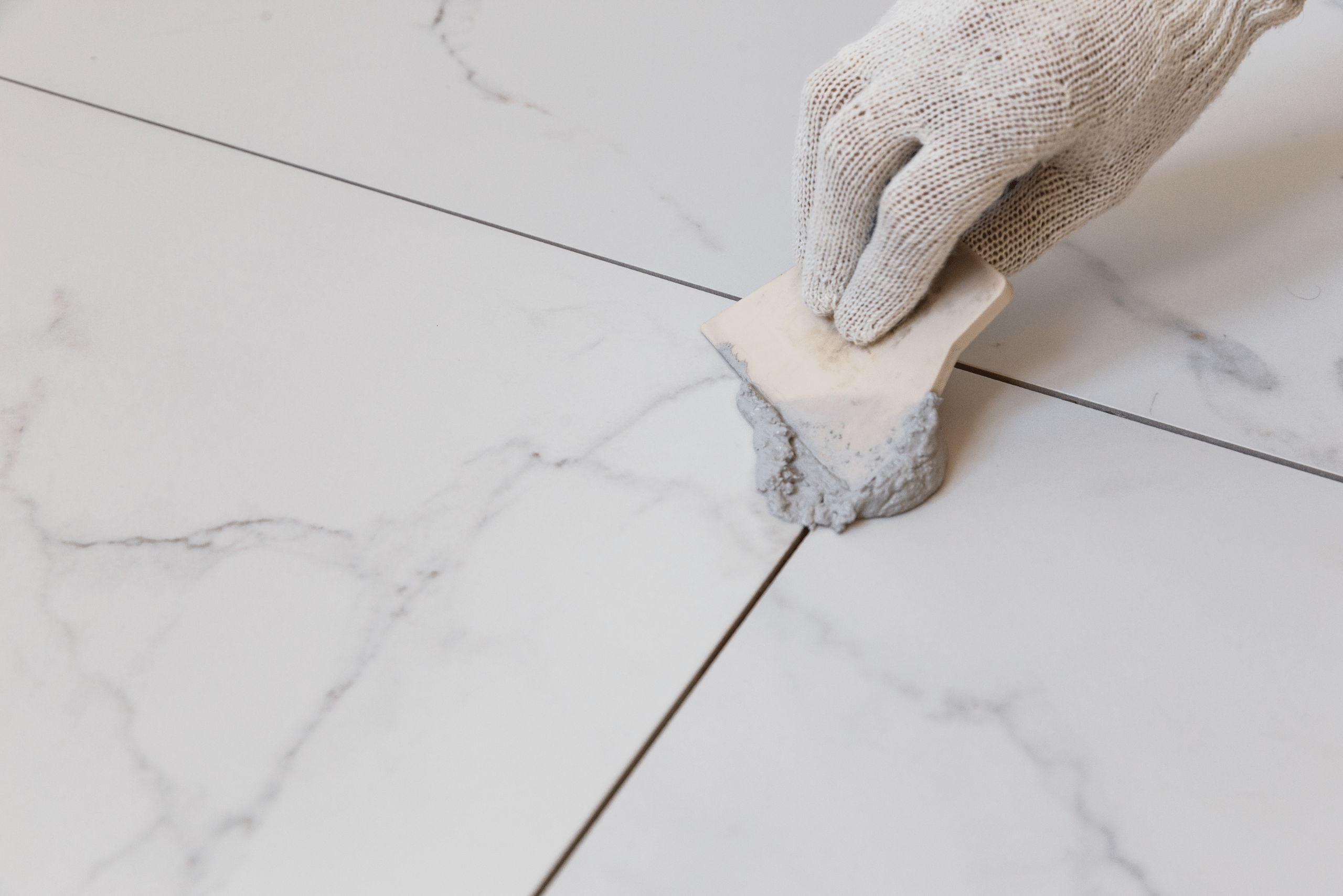 Spreading new grout on bathroom tile.