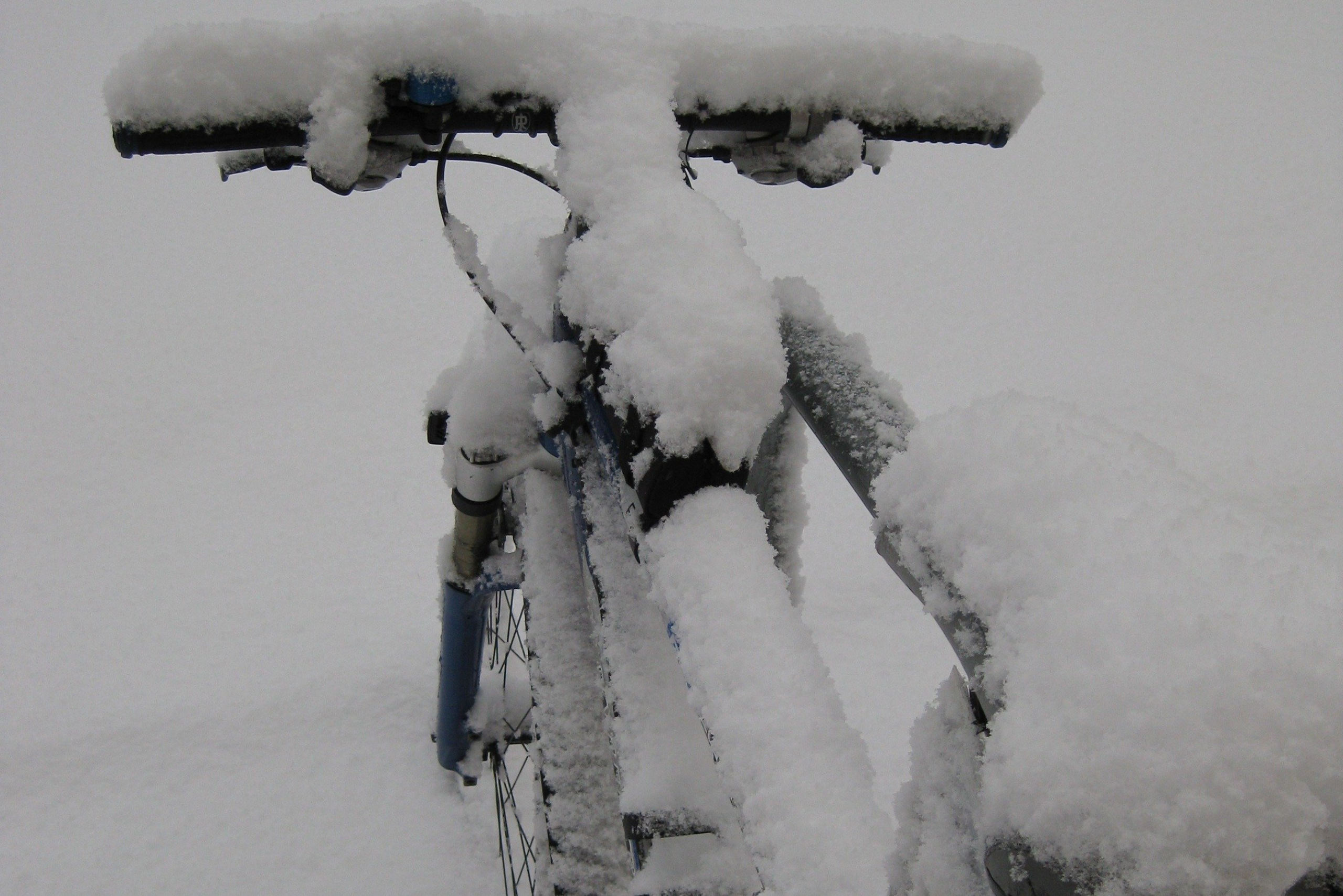 Closeup of a bicycle covered in snow.