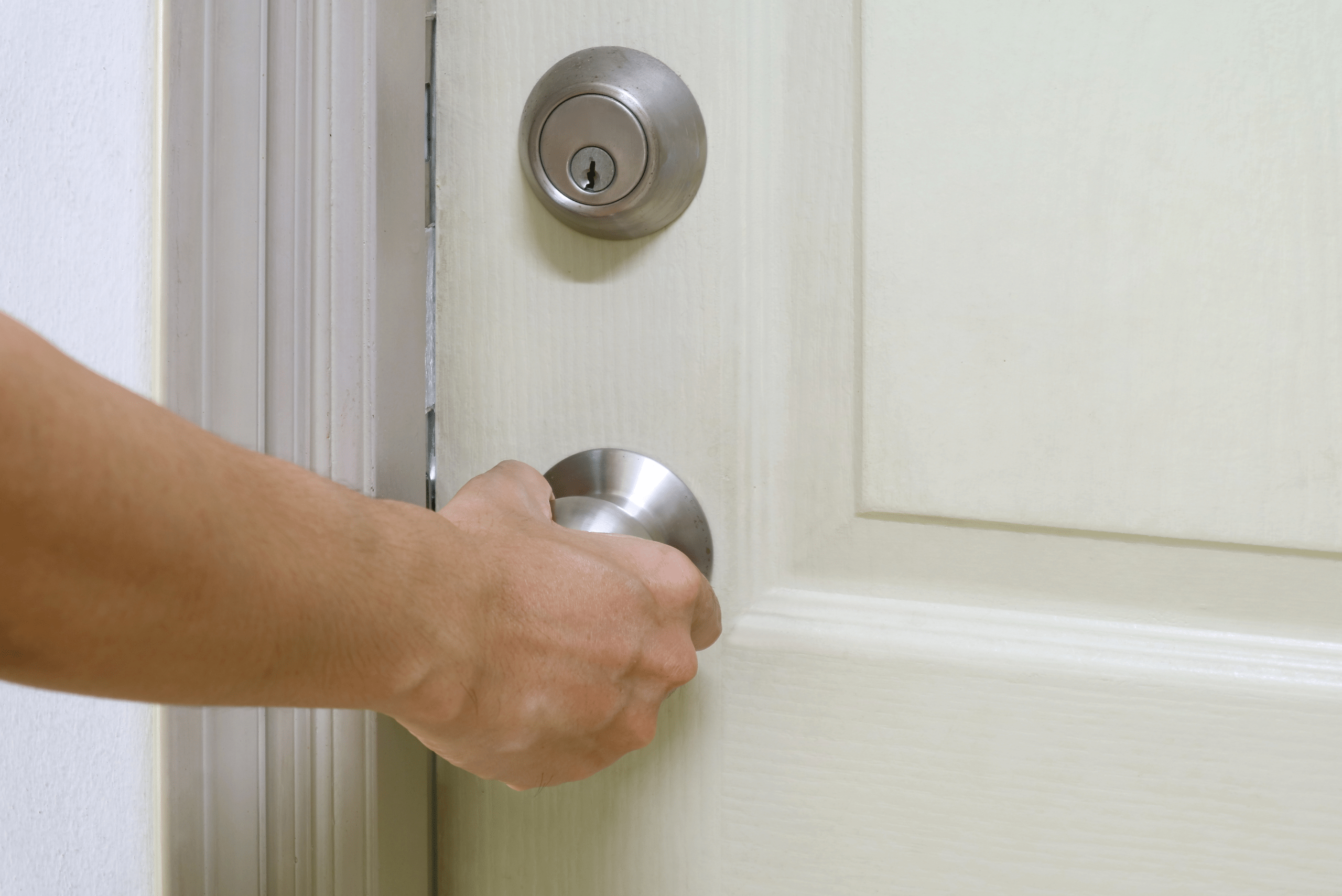 Closeup of someone's hand opening a door.