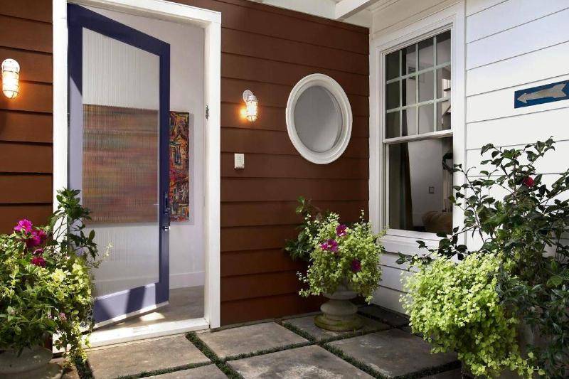 A circular mirror hangs to the right of the front door.