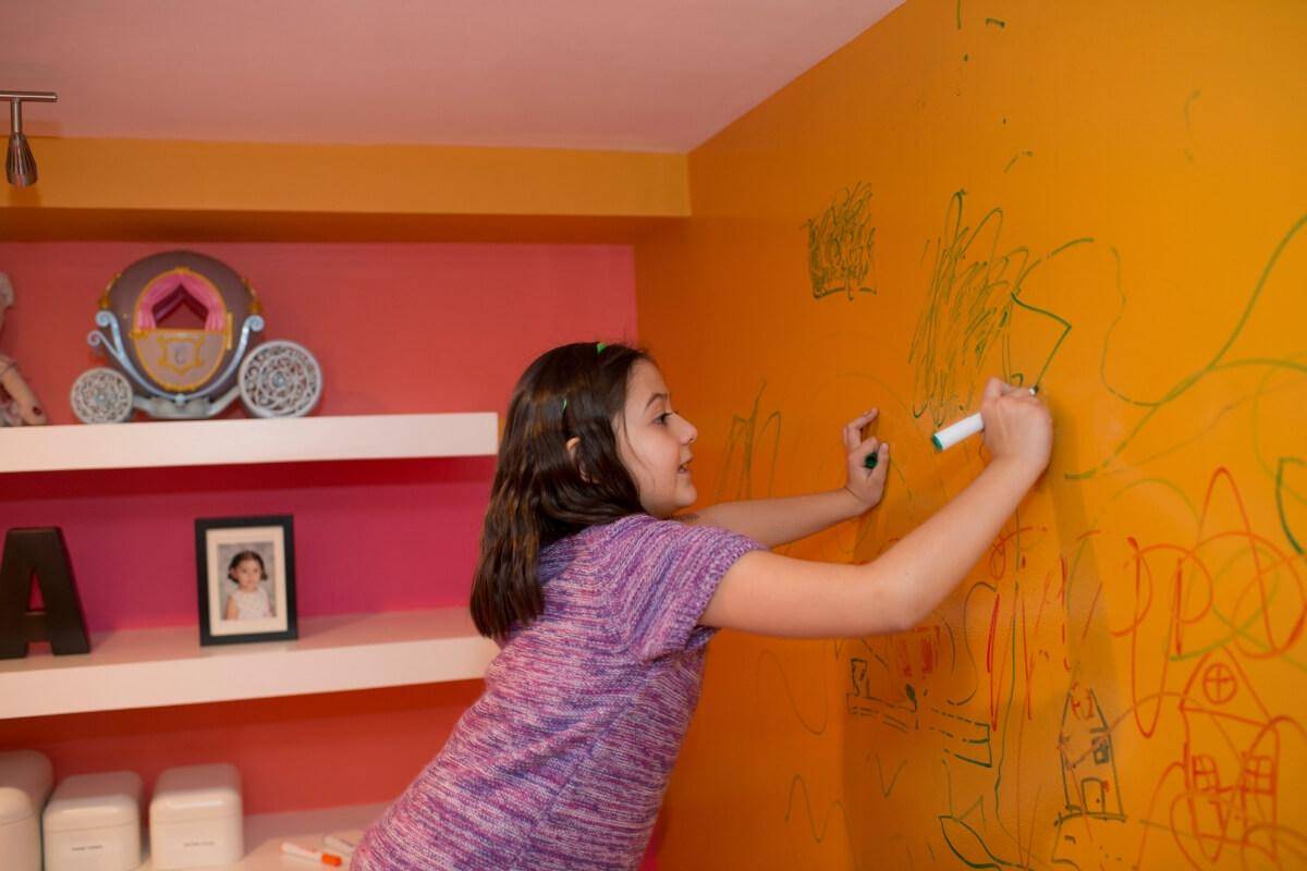 Kid using a market on the wall