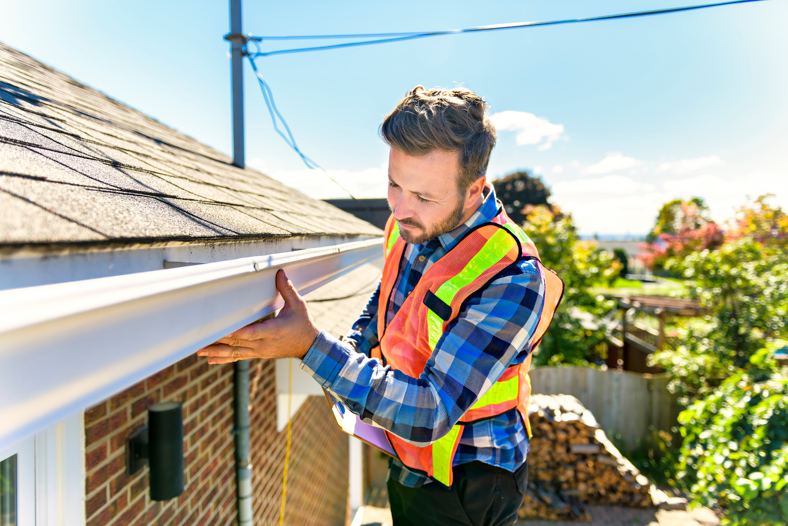 Man inspecting roof and gutters.