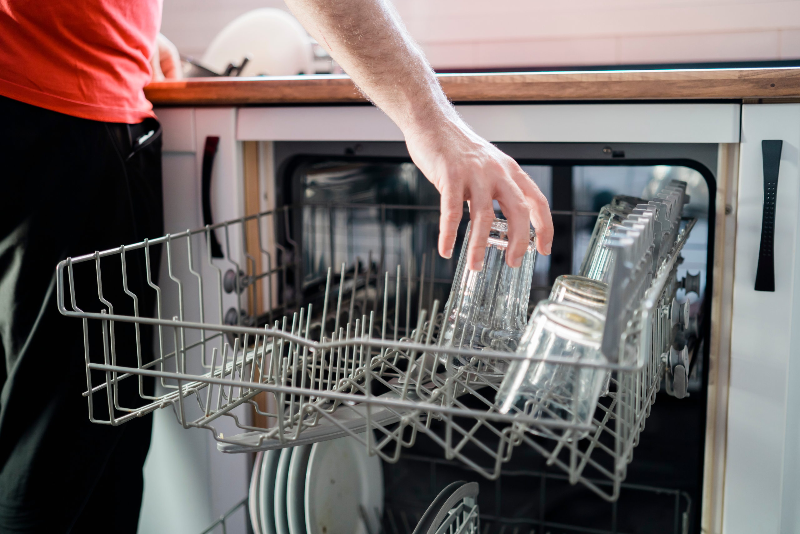 Loading top rack of a dishwasher.