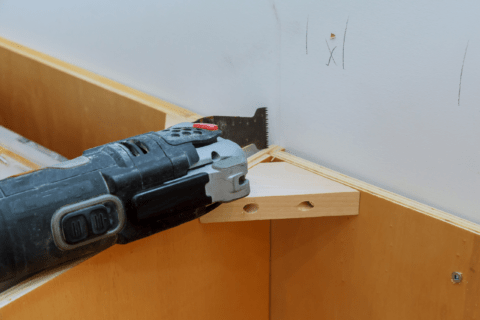 Oscillating tool making a cut in a corner.