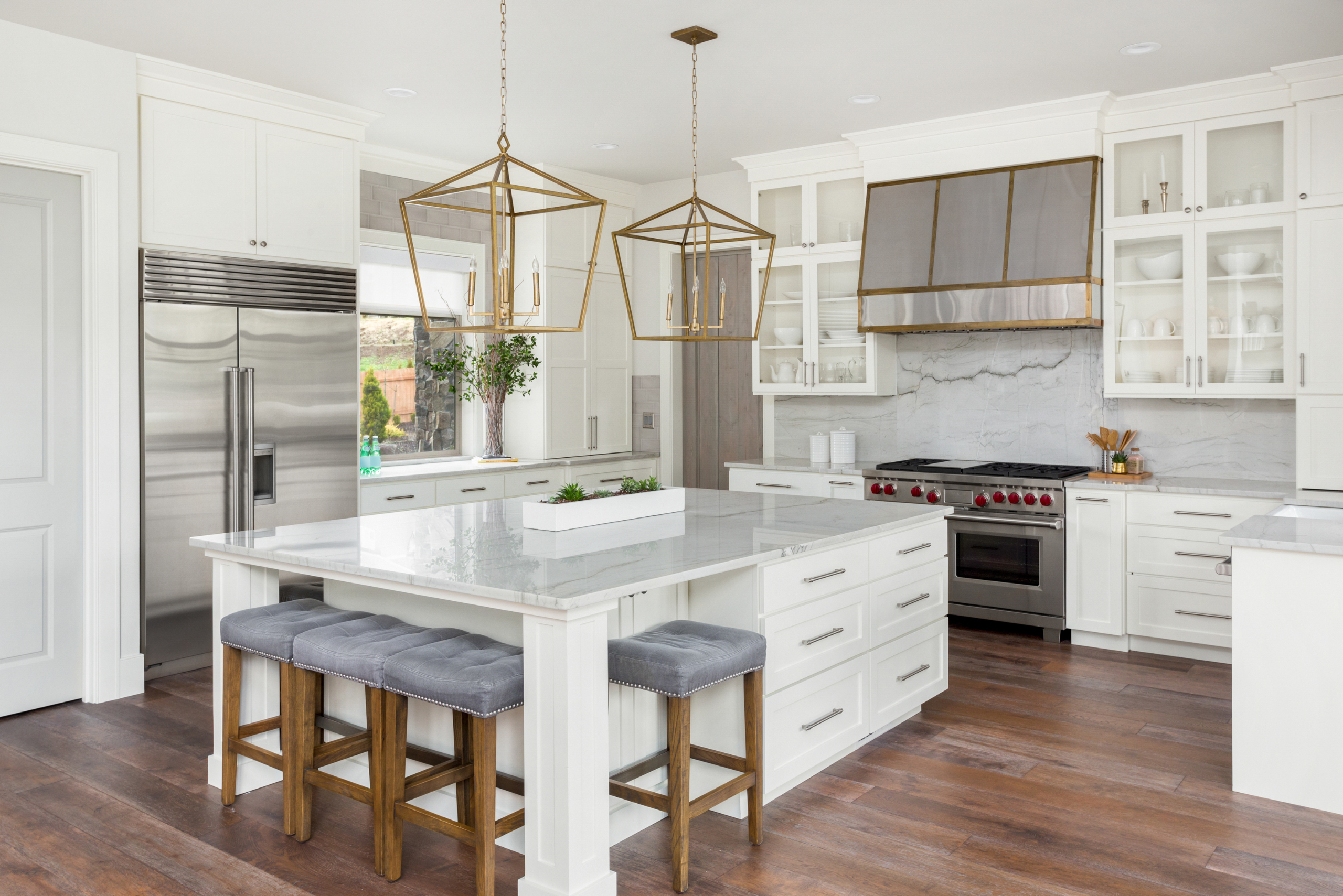 Modern kitchen with white cabinets and unique lights.