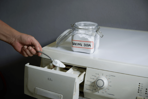 Adding baking soda to laundry.