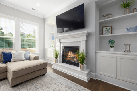 Living room with a TV mounted above fireplace.