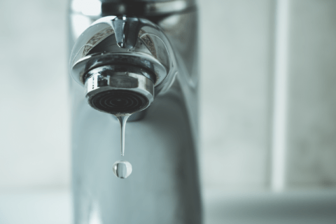 Closeup of dripping water from faucet.