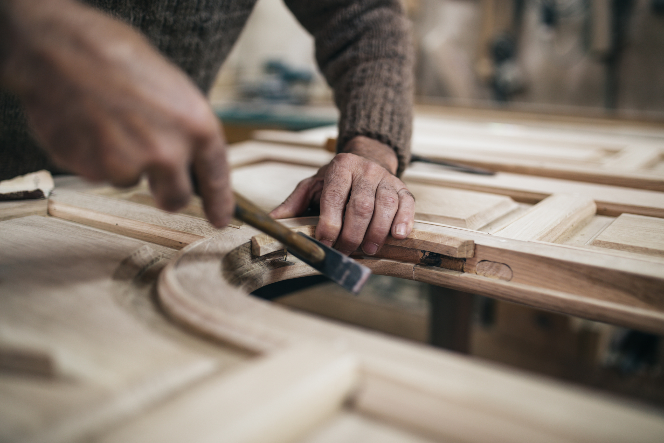 Man working on a wooden door for a house.