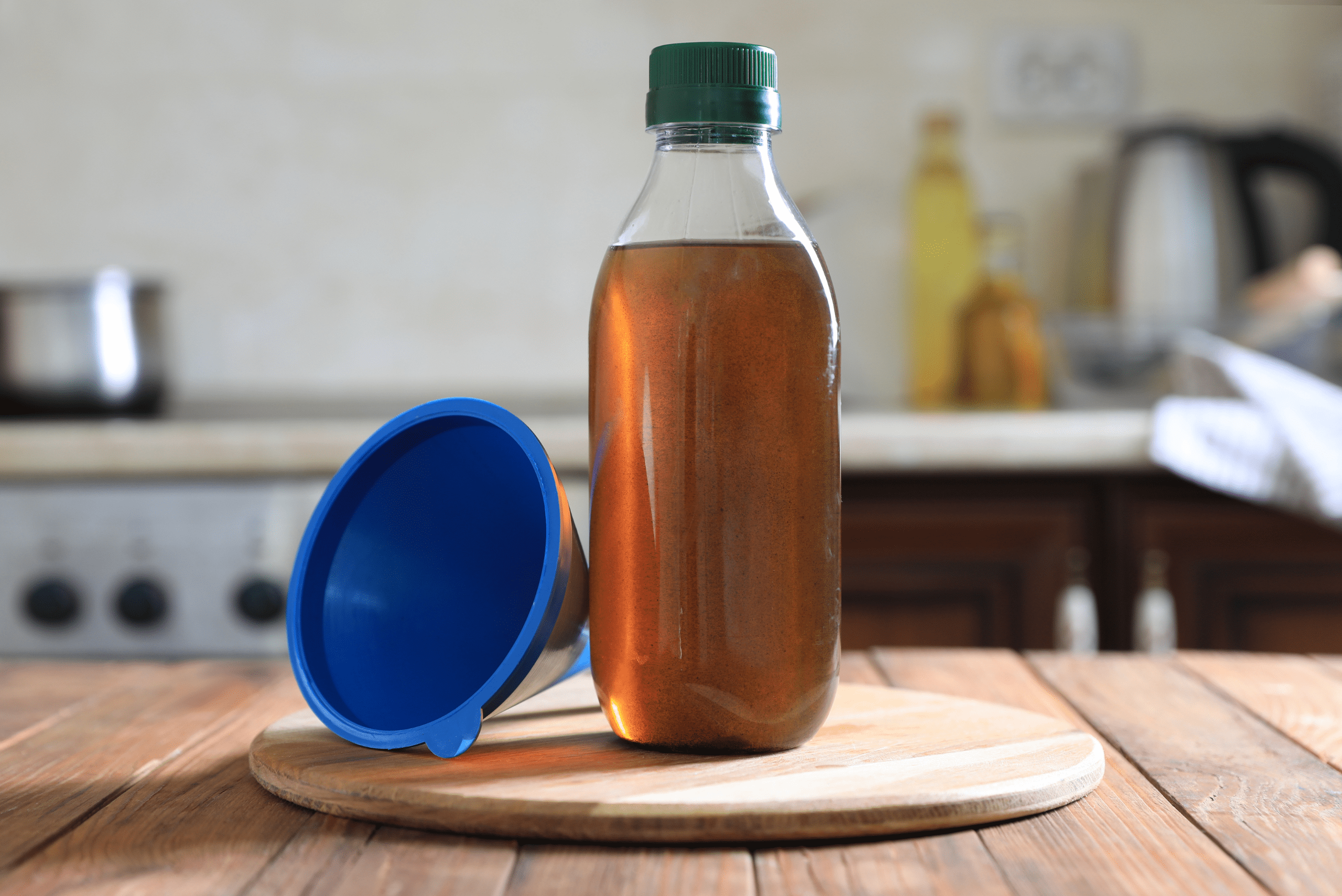 Cooking oil in bottle and a blue funnel.