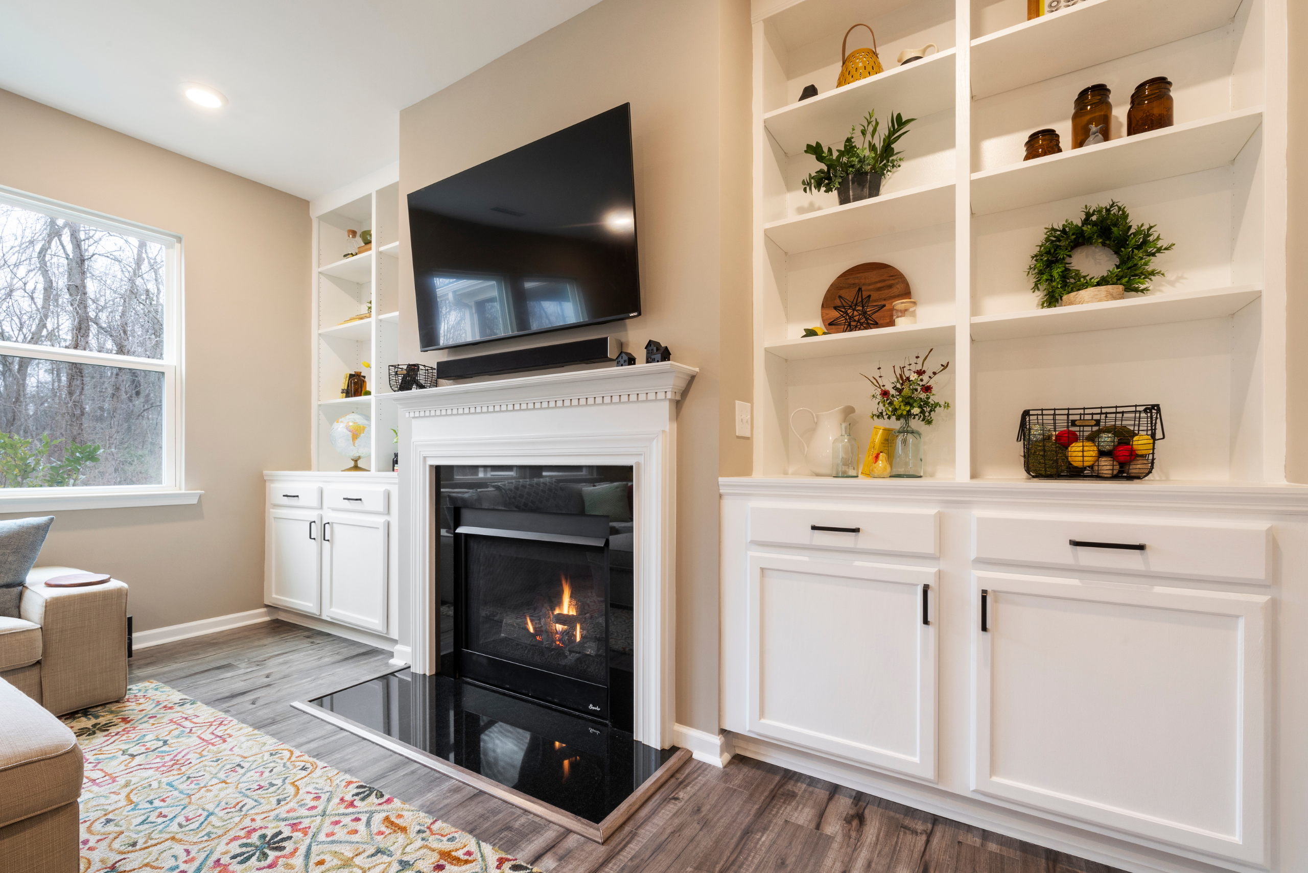 Bright living room with TV above a fireplace.