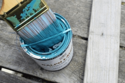 Using rubber band on paint can to catch drips of paint from brush.