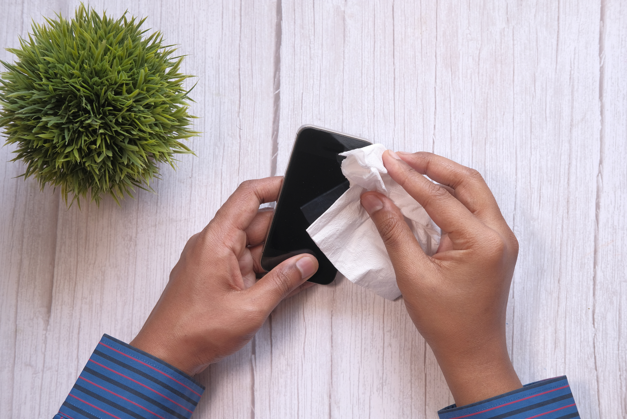 Using a wipe to clean the screen of a smartphone.