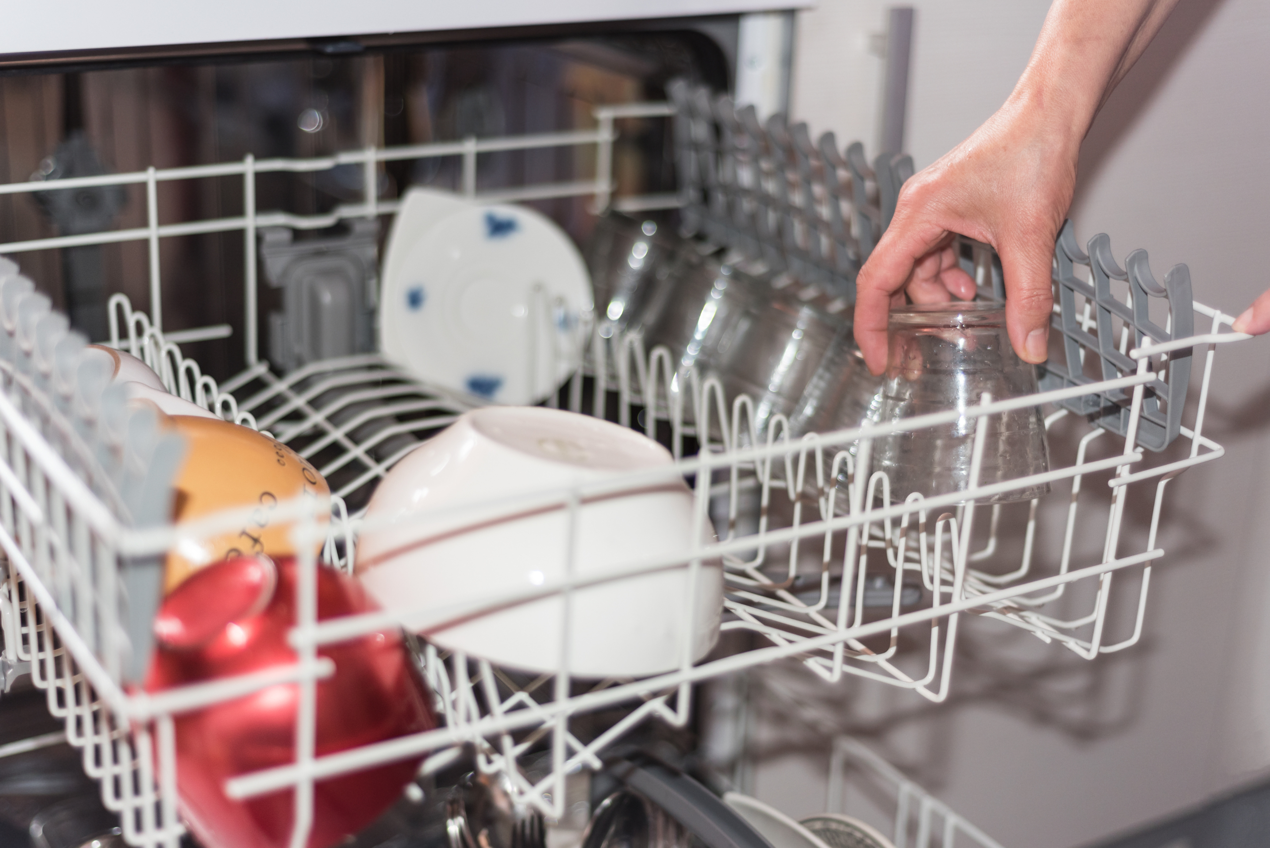 Loading top rack of a dishwasher.