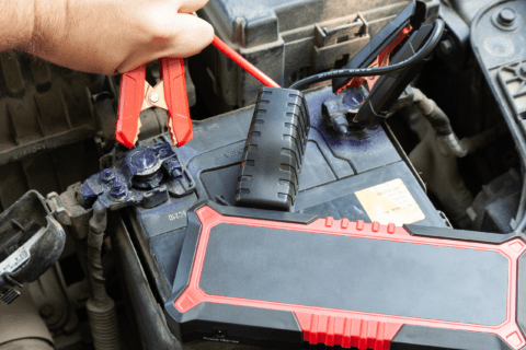 Attaching portable car jumper starter to a car's battery.