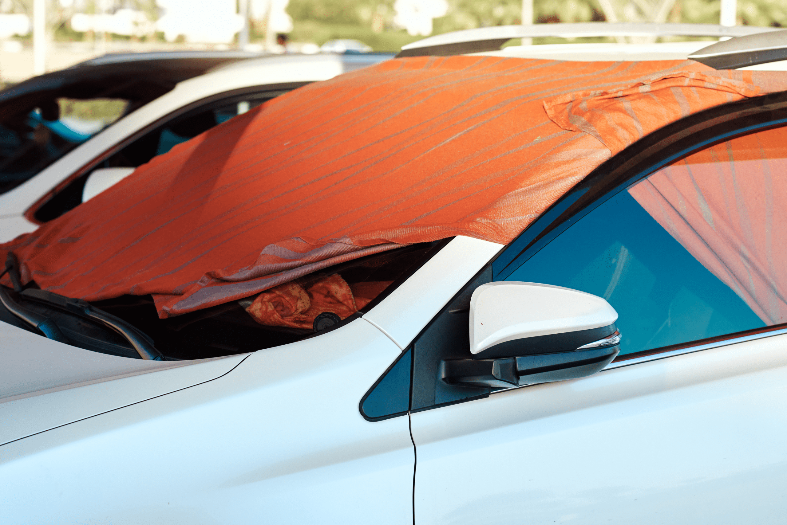 Car windshield with orange cover on it.