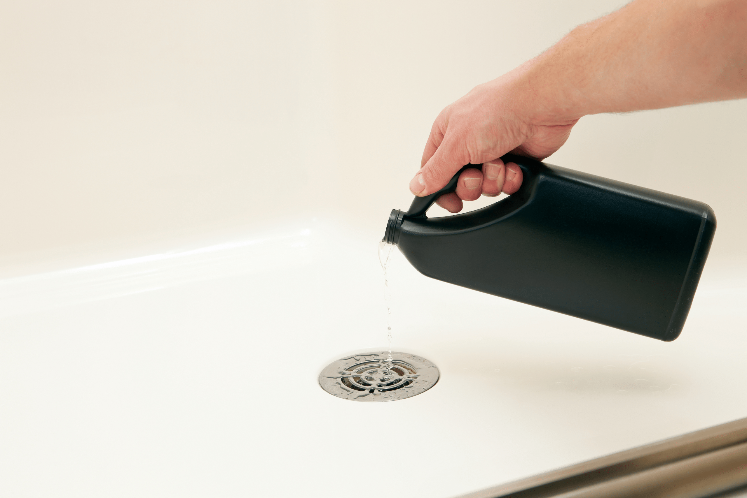 Pouring drain cleaning liquid down drain.