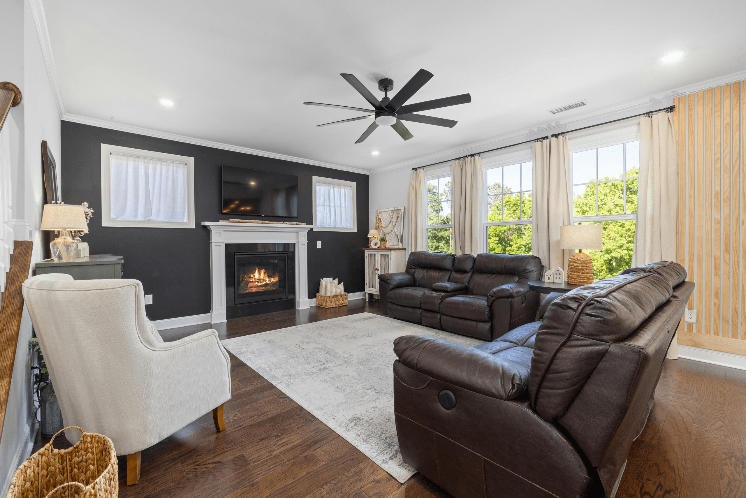 Living room with a ceiling fan and a TV above the fireplace.