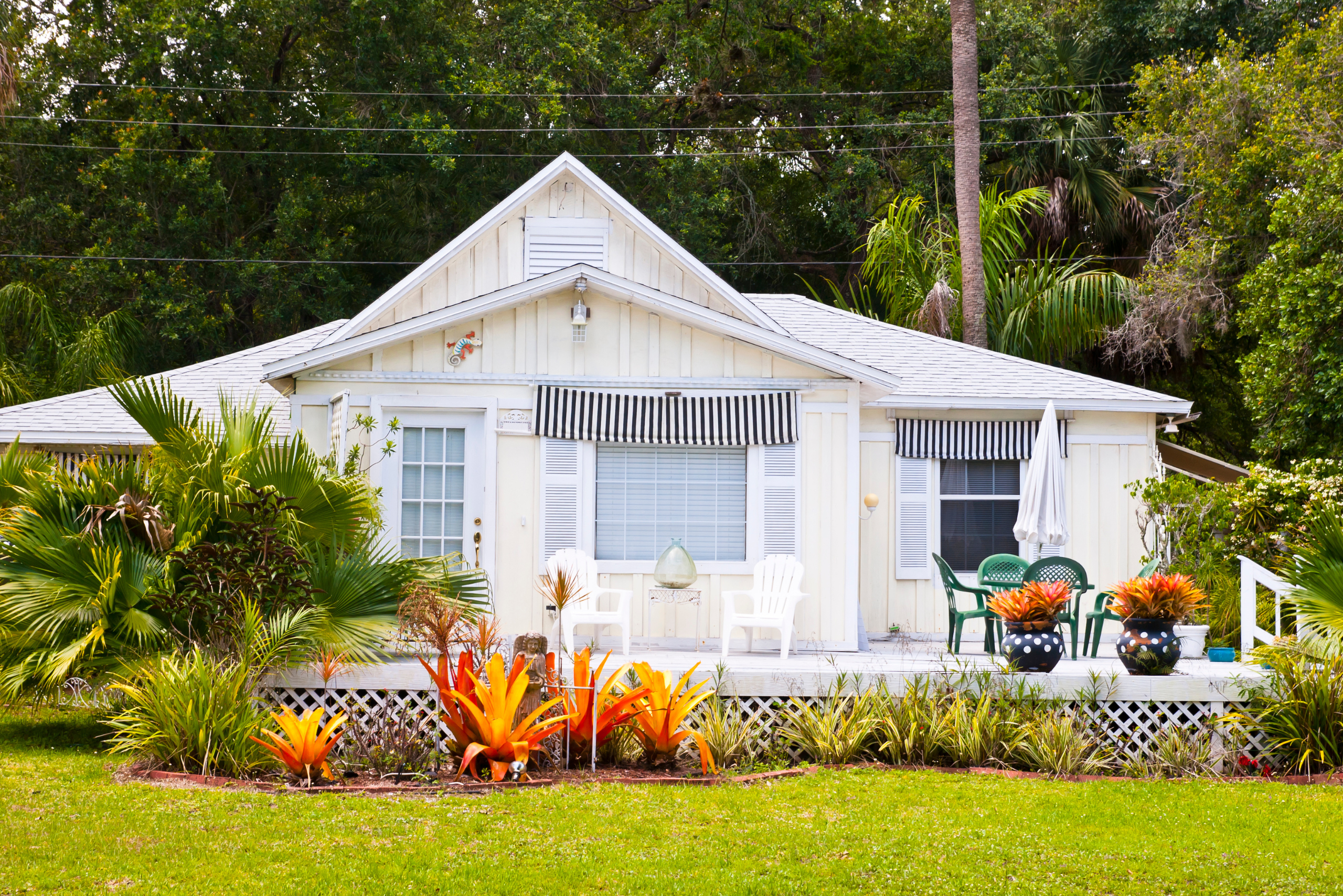 Exterior of a white house with tidy landscaping.