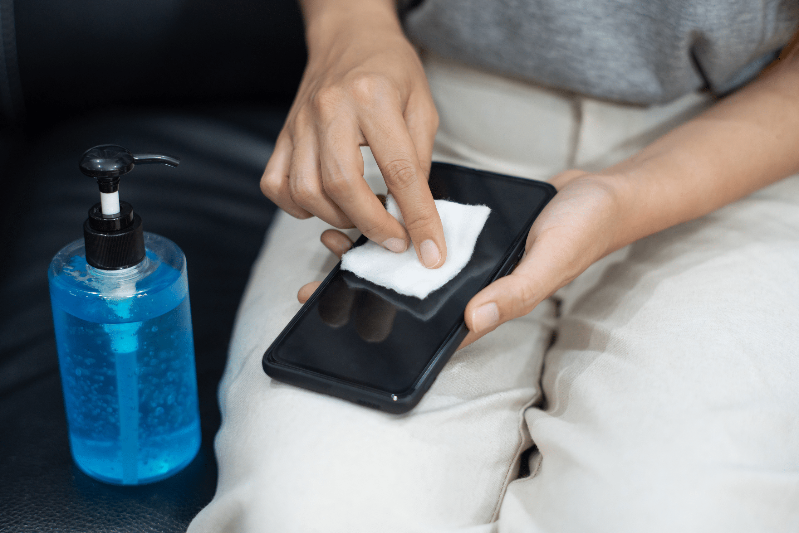 Person wiping down a smartphone.