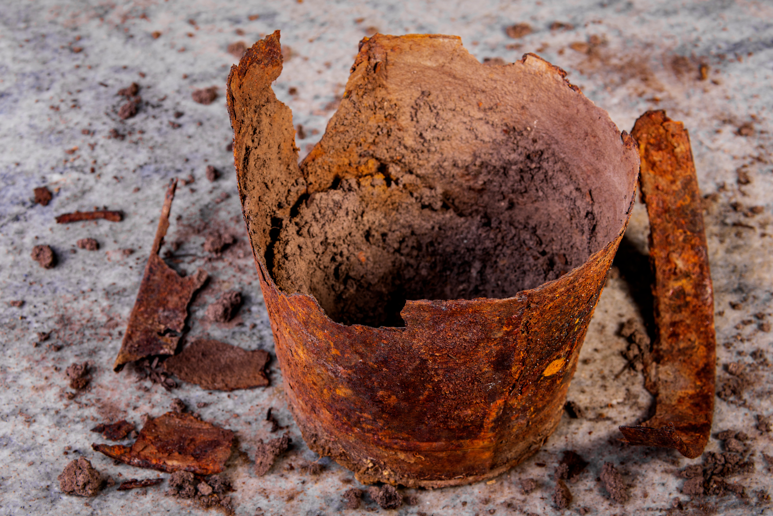 Rusty plant pot that's falling apart.