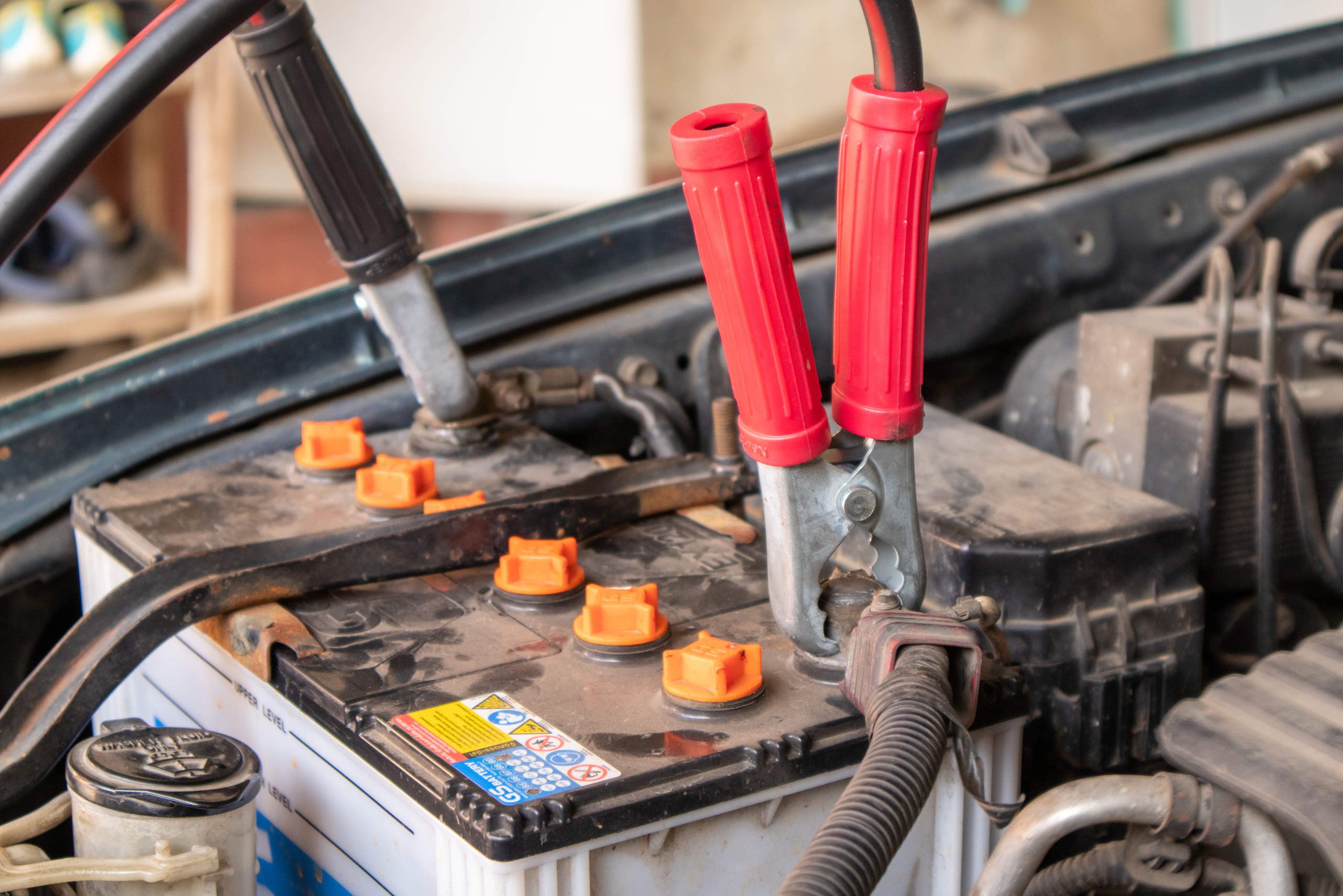 Car battery attached to jumper cables.