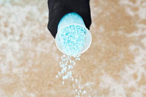 Spreading blue salt from a cup.