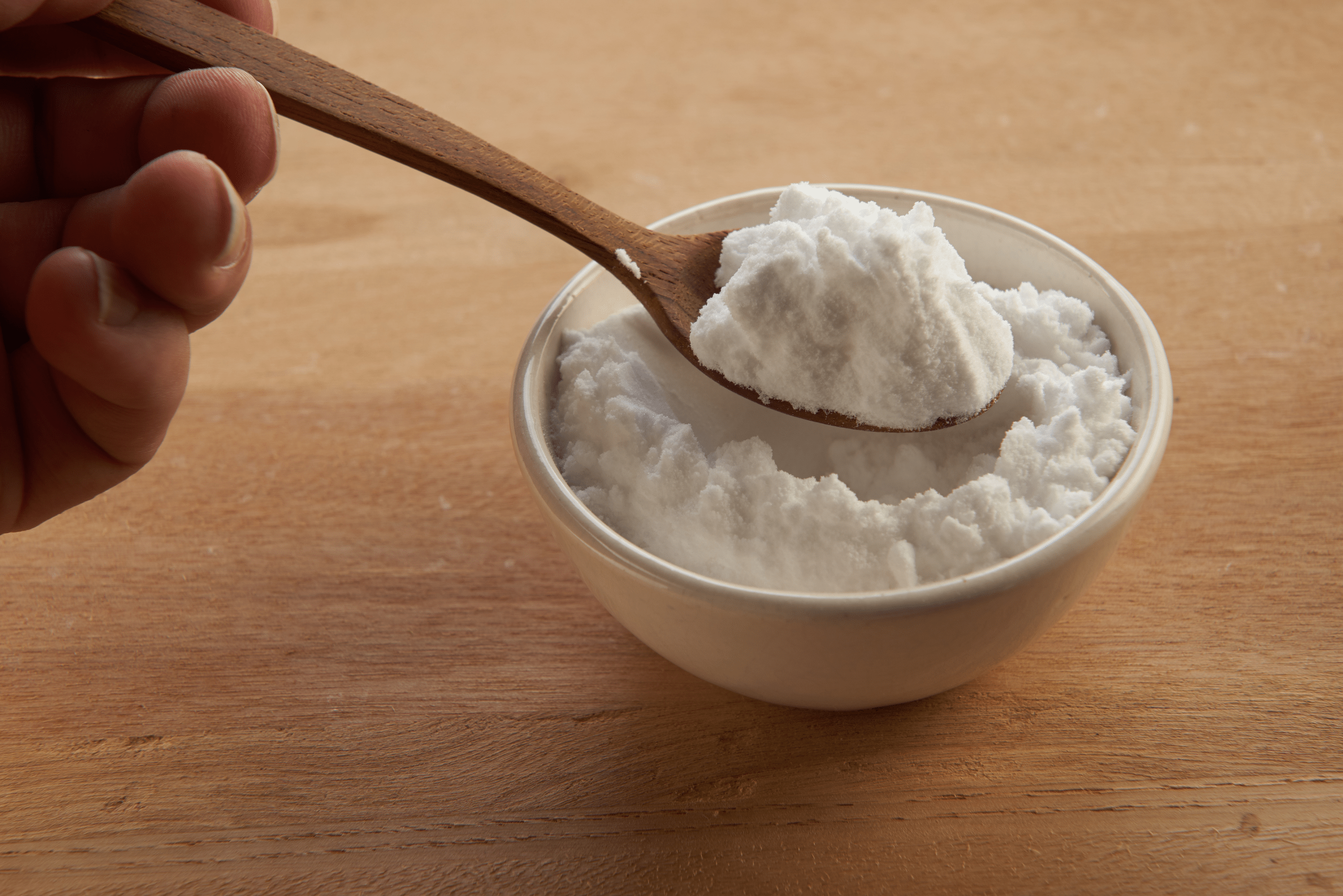 Baking soda paste with wooden spoon.