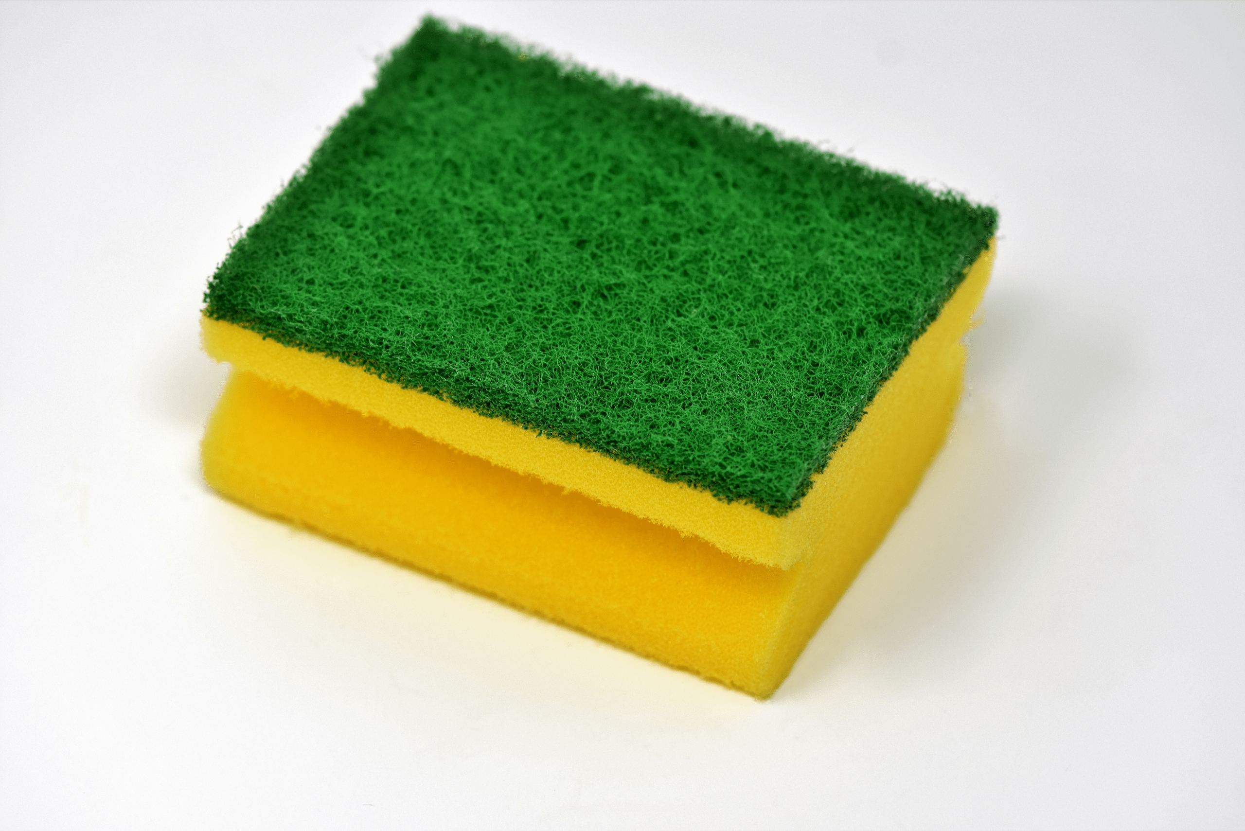 Yellow kitchen sponge with green abrasive side up.