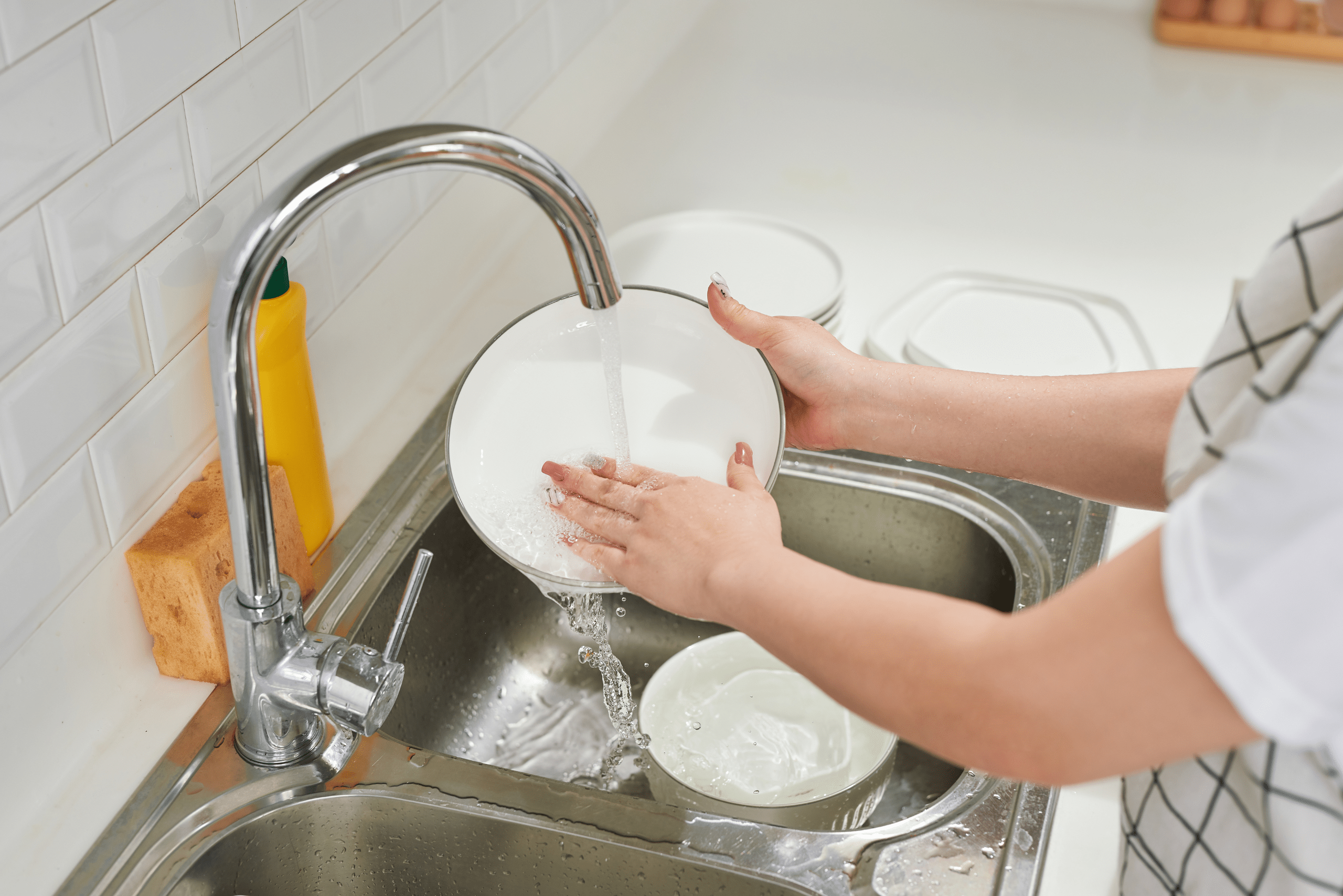 Rising dishware in the the sink.