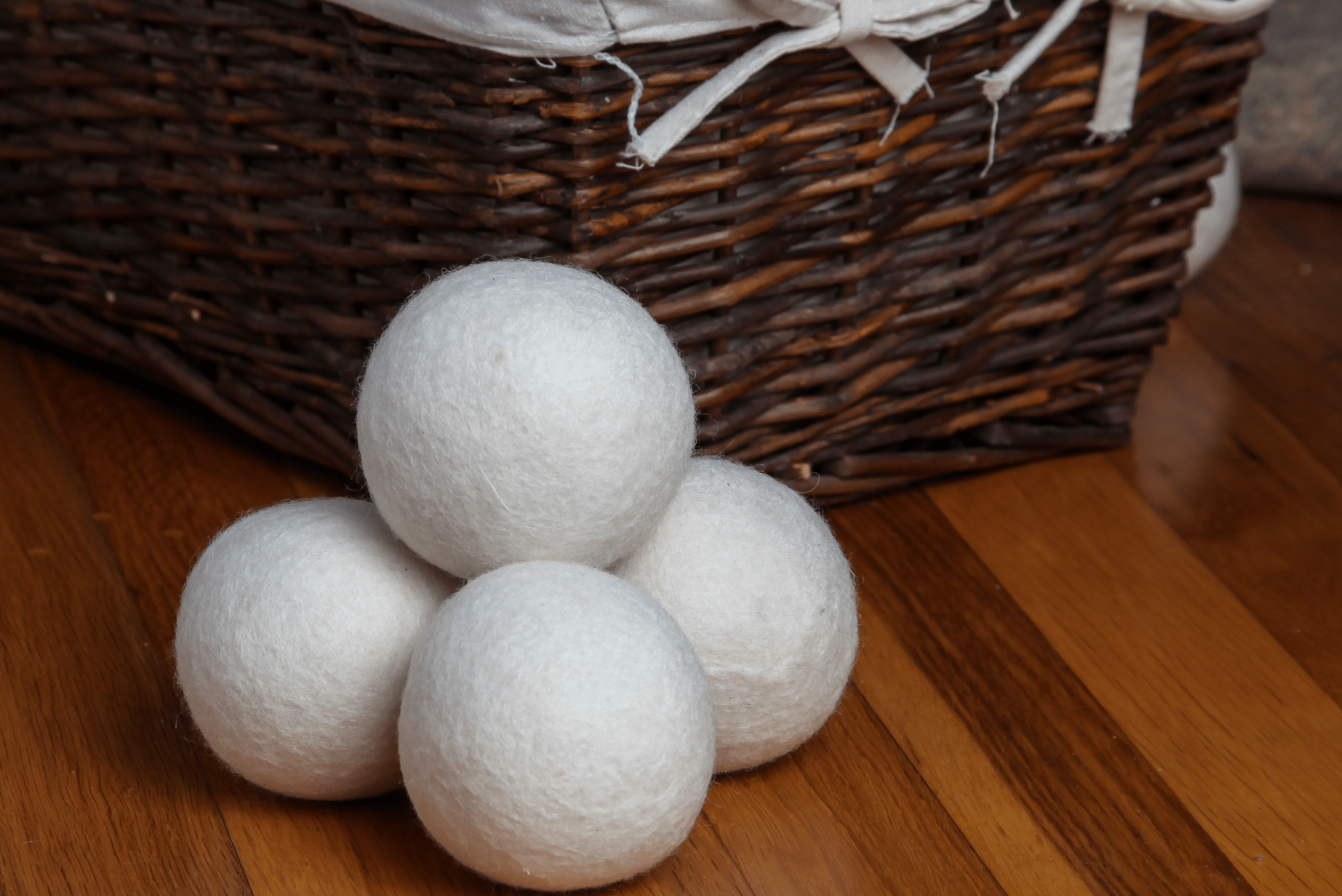 Wool balls stacked on top of each other in front of a basket.