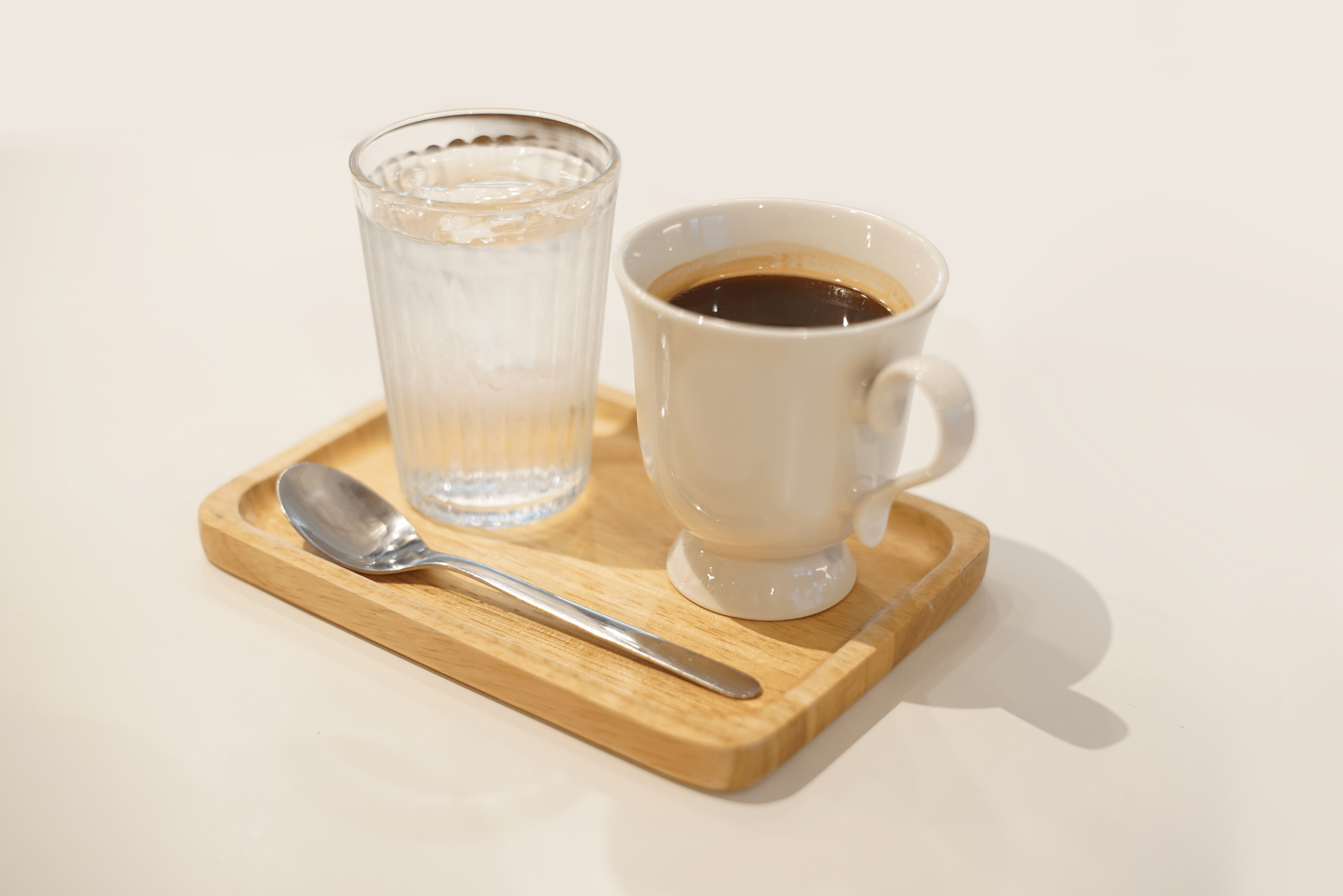 Water and coffee on a wooden tray.