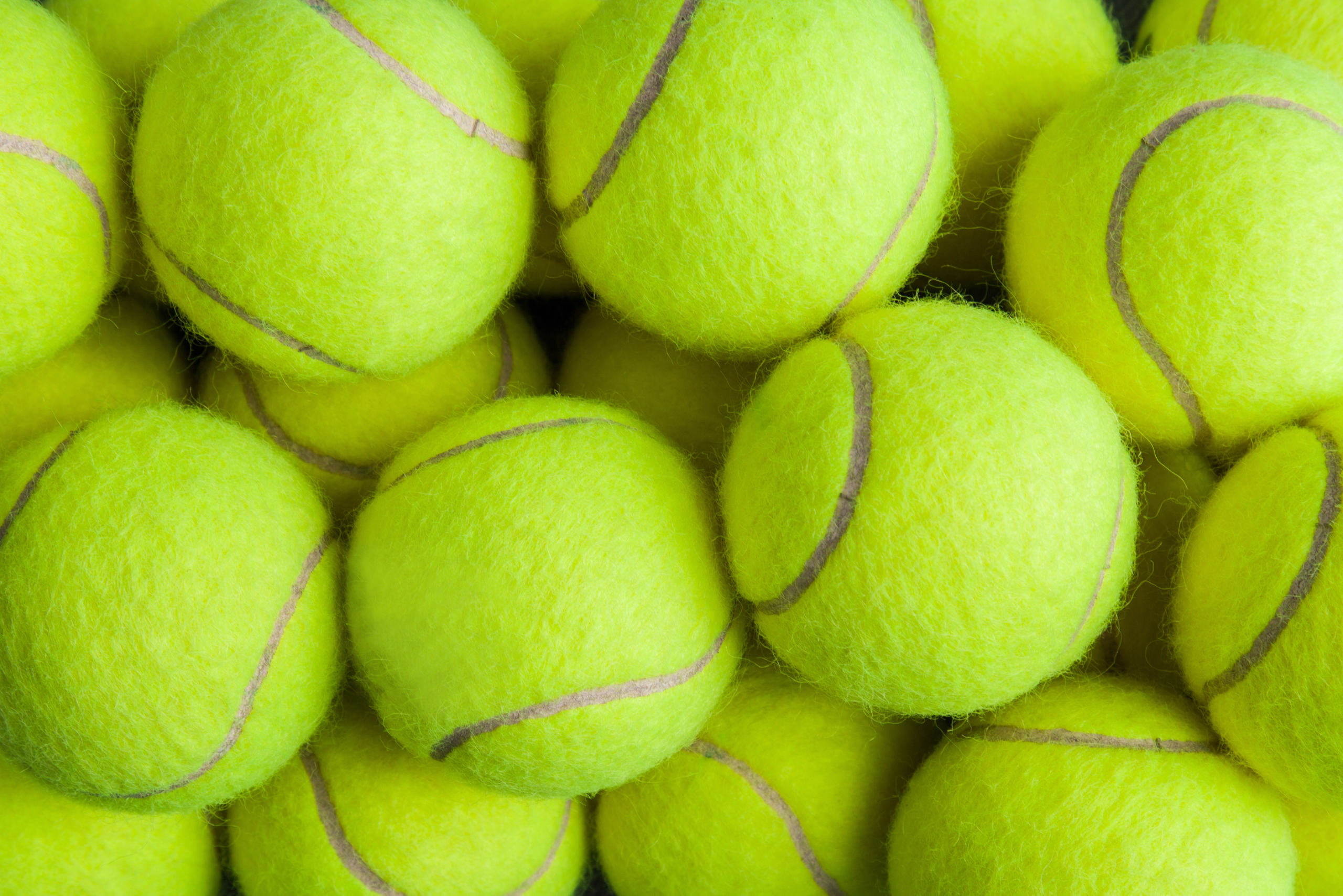 Bunch of stacked green tennis balls.