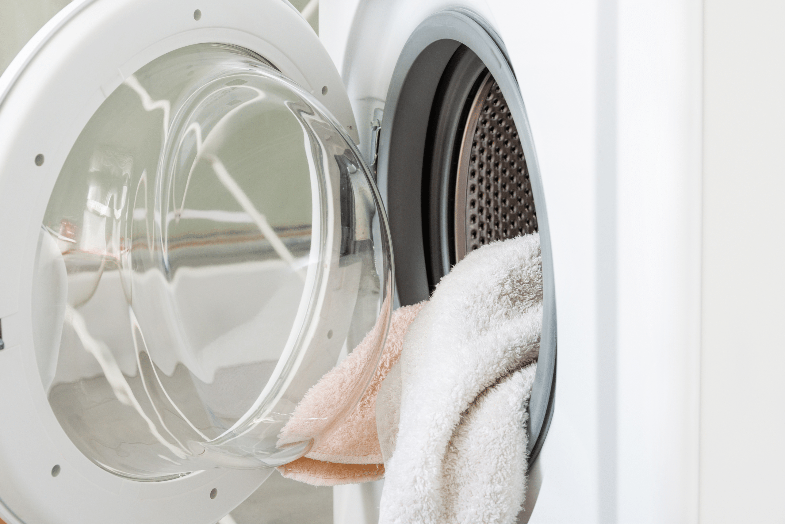 Towels being put into the washing machine.