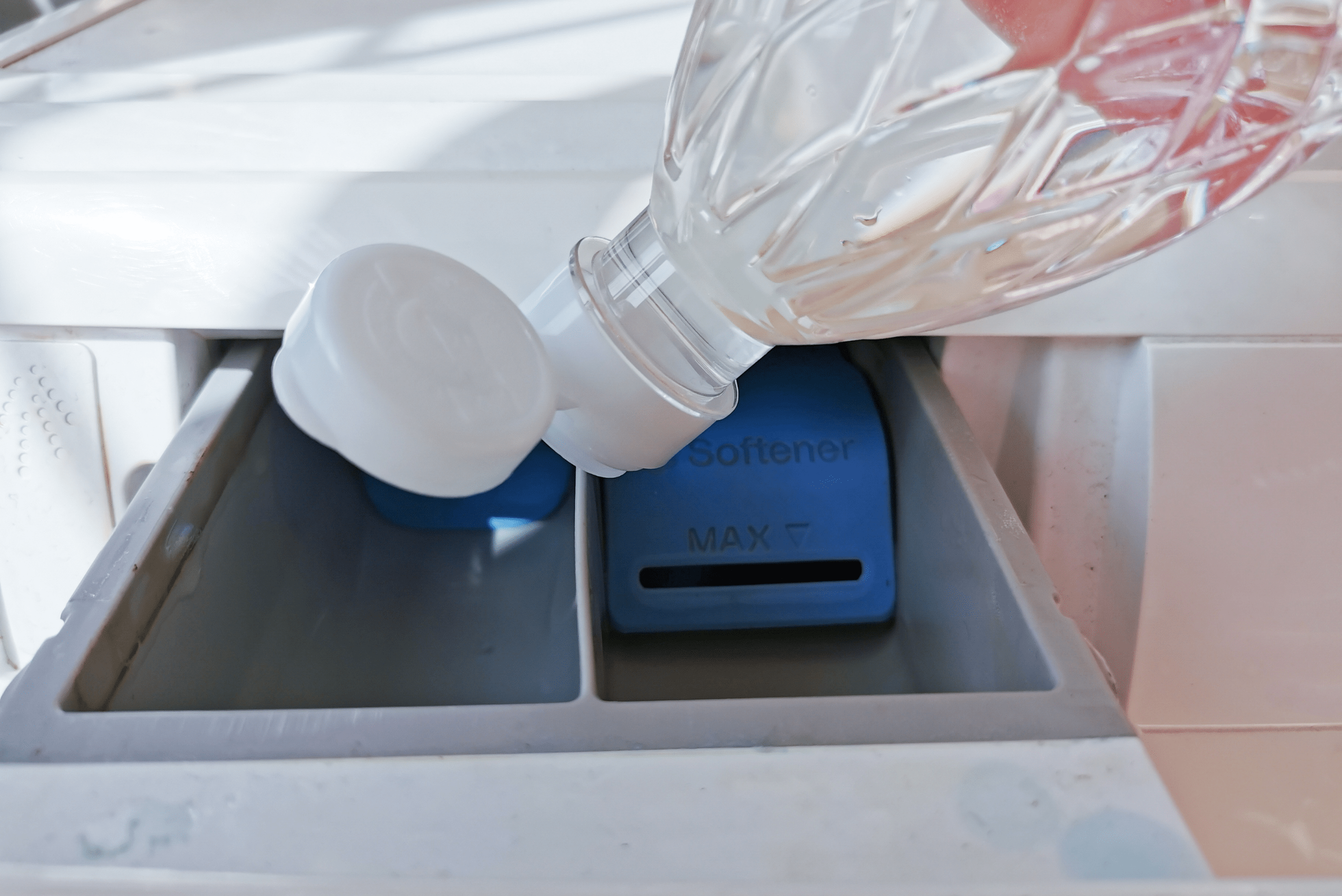 Adding vinegar to washing machine drawer.