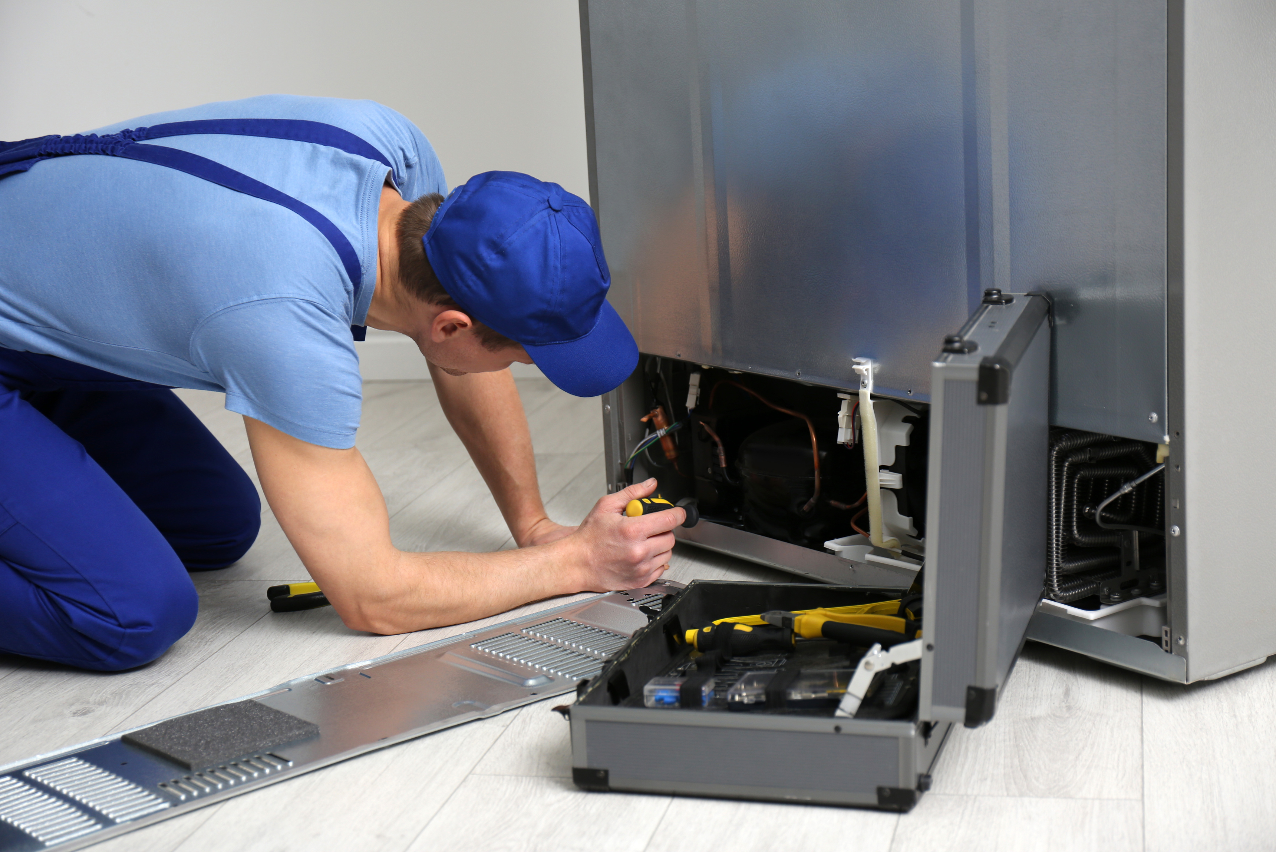 Worker fixing fridge.