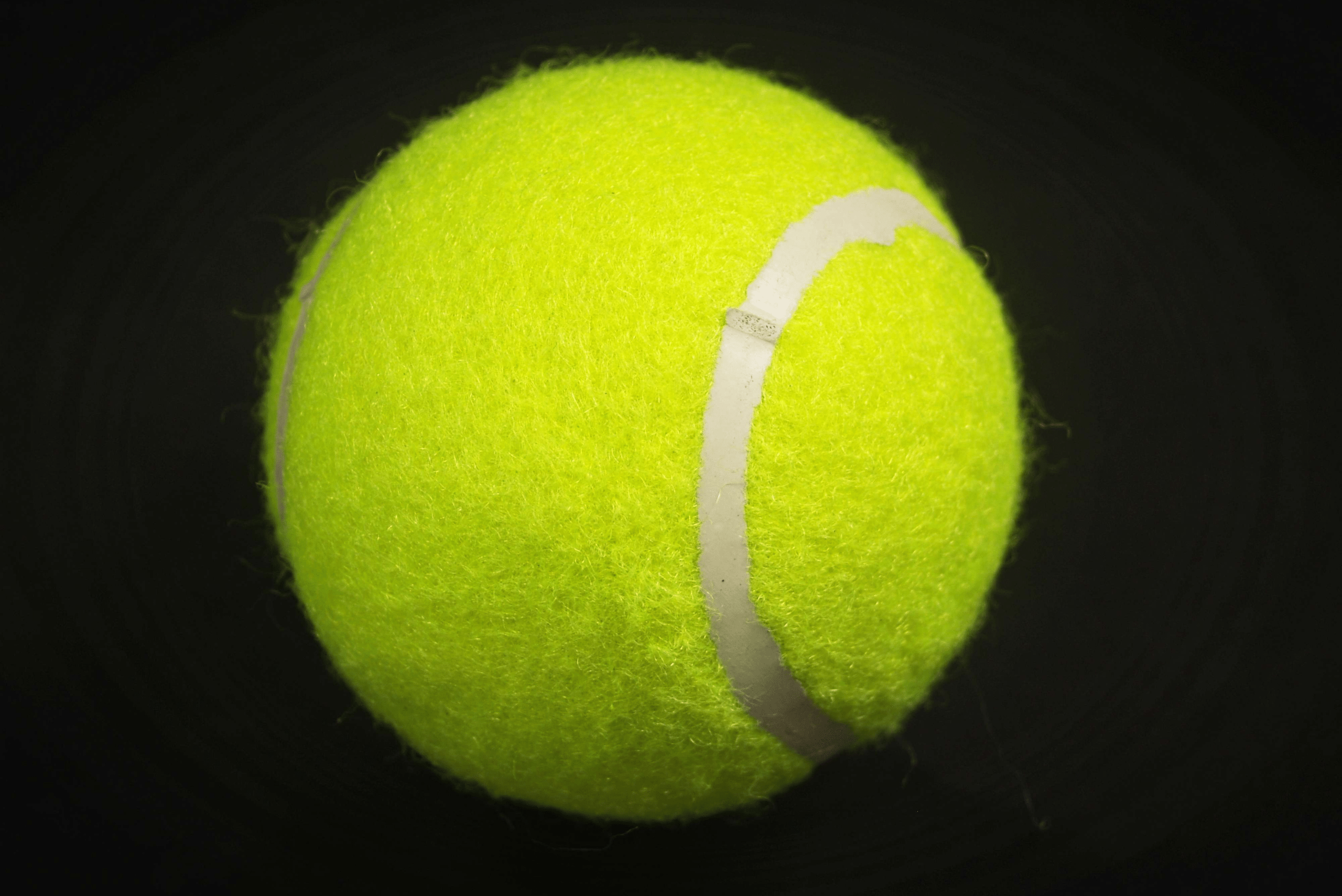 Tennis ball with a black background.